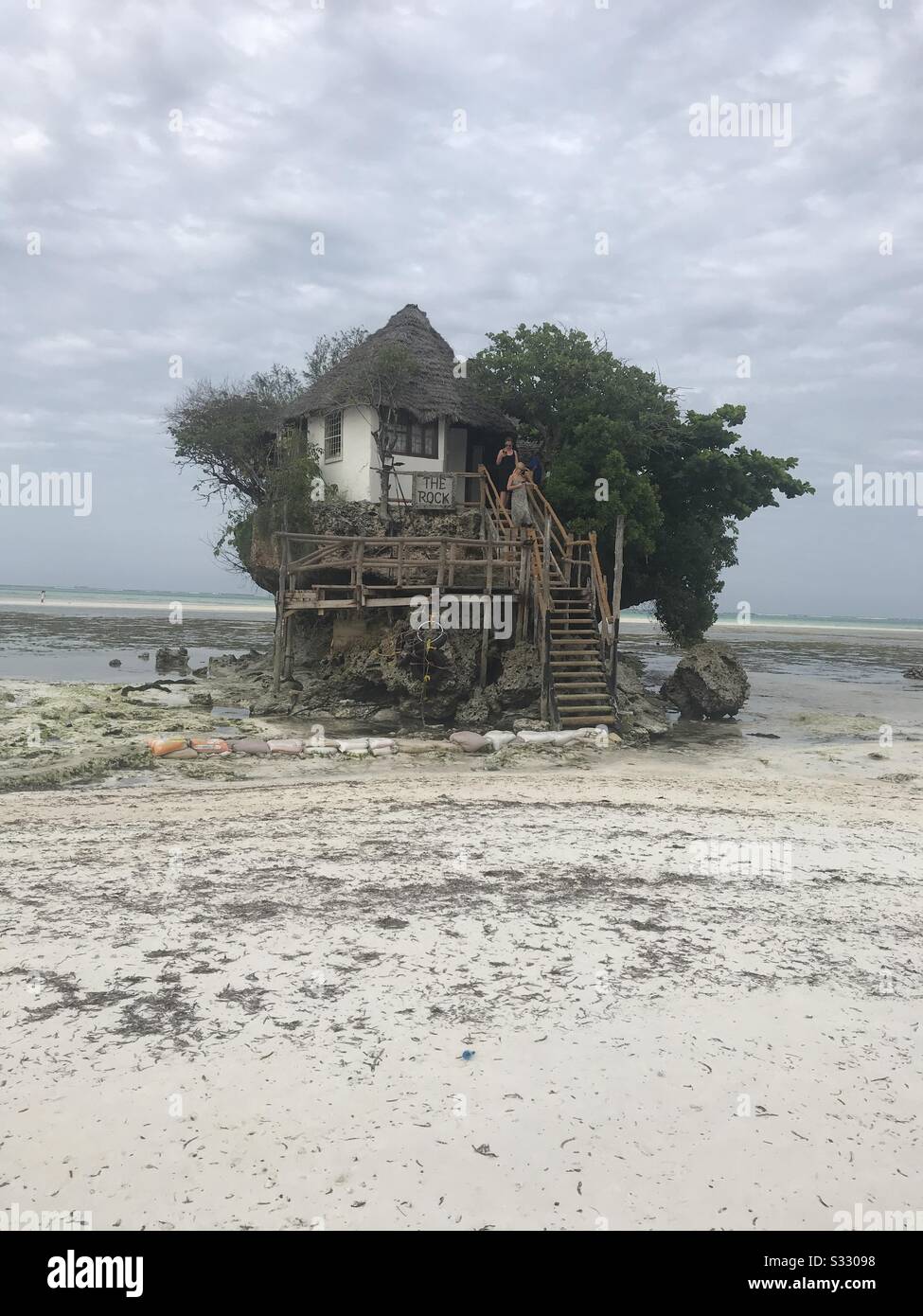 Der Felsen: Eine winzige Insel östlich der Insel Sansibar, die Menschen bei Ebbe zu Fuß erreichen können, enthält ein Restaurant und ein paar Bäume. Stockfoto