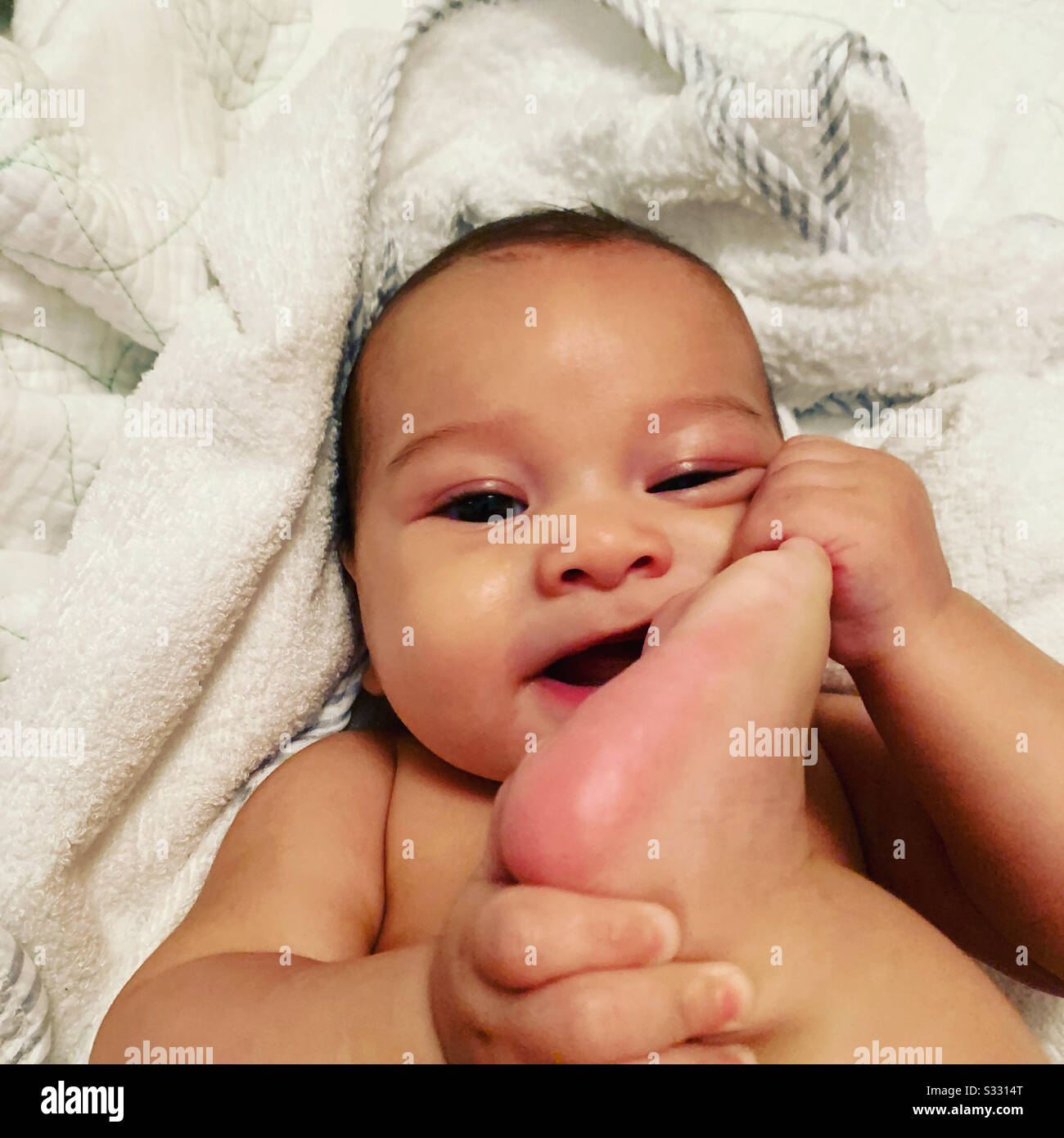 Baby findet seine Zehe Stockfoto