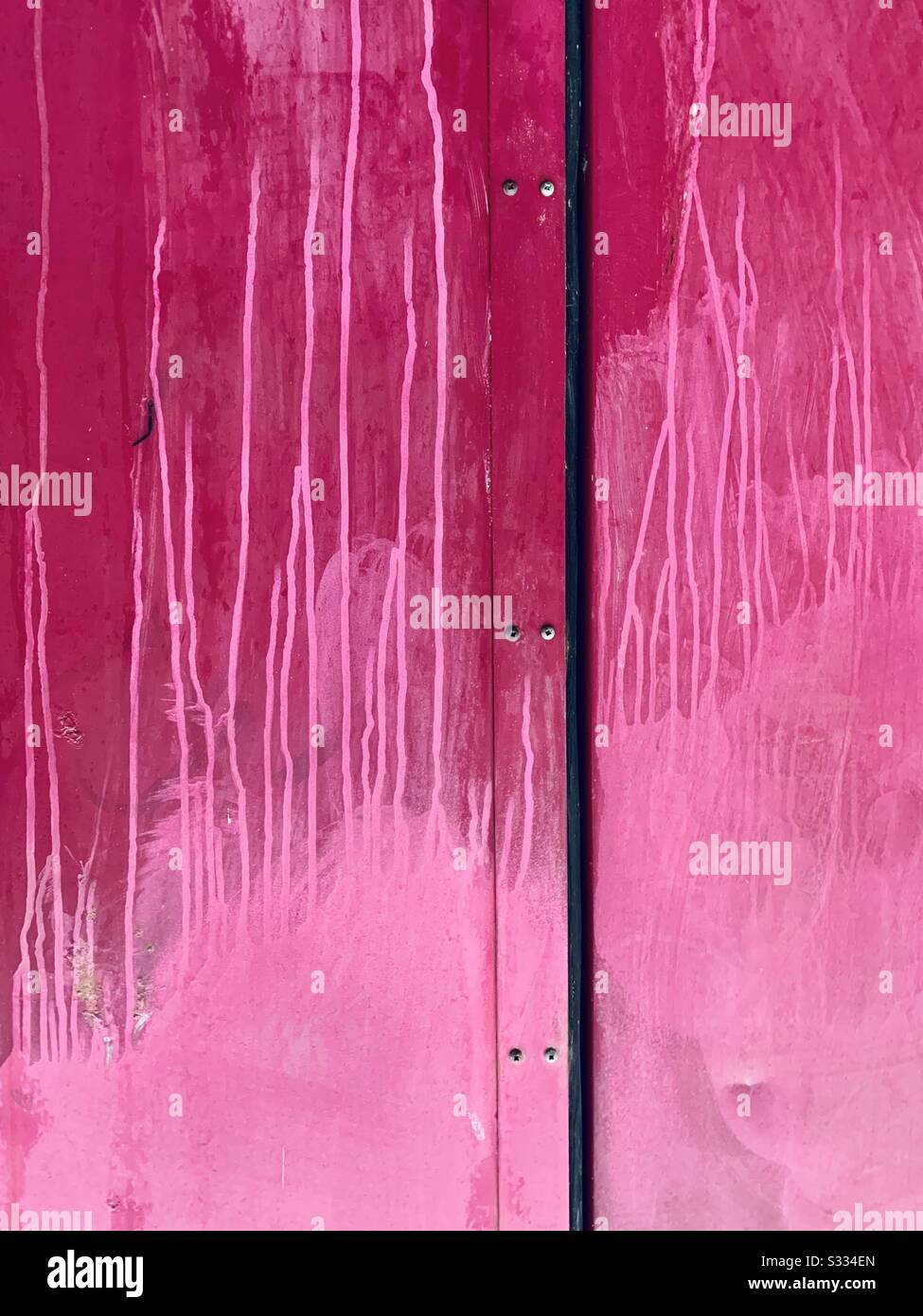 Rosafarbene Tür mit tropfender Farbe Stockfoto