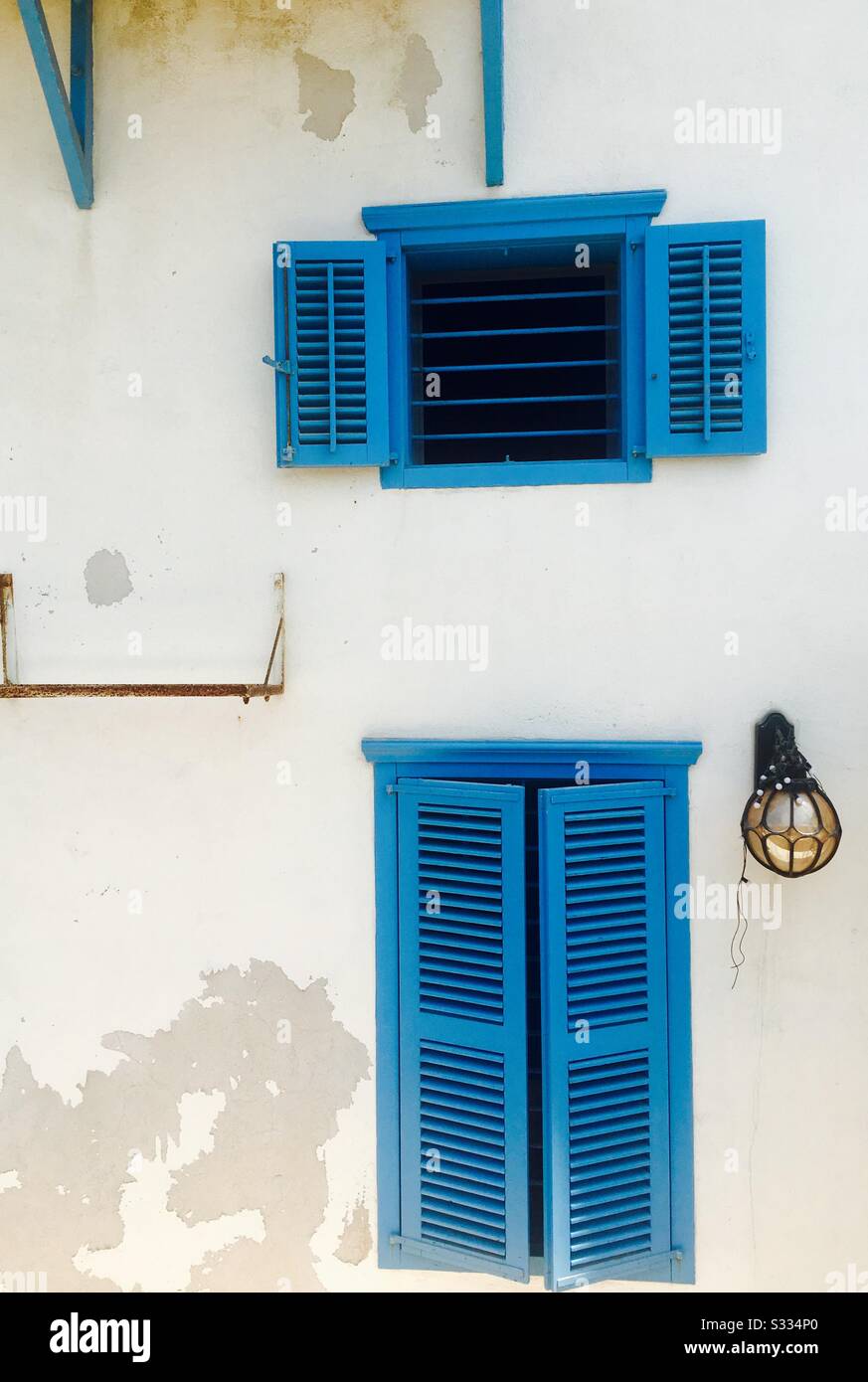 Blaue Fenster im mediterranen Stil schmücken ein altes Haus in Jaffa, Israel. - Smartphone-aufgenommenes Stockfoto