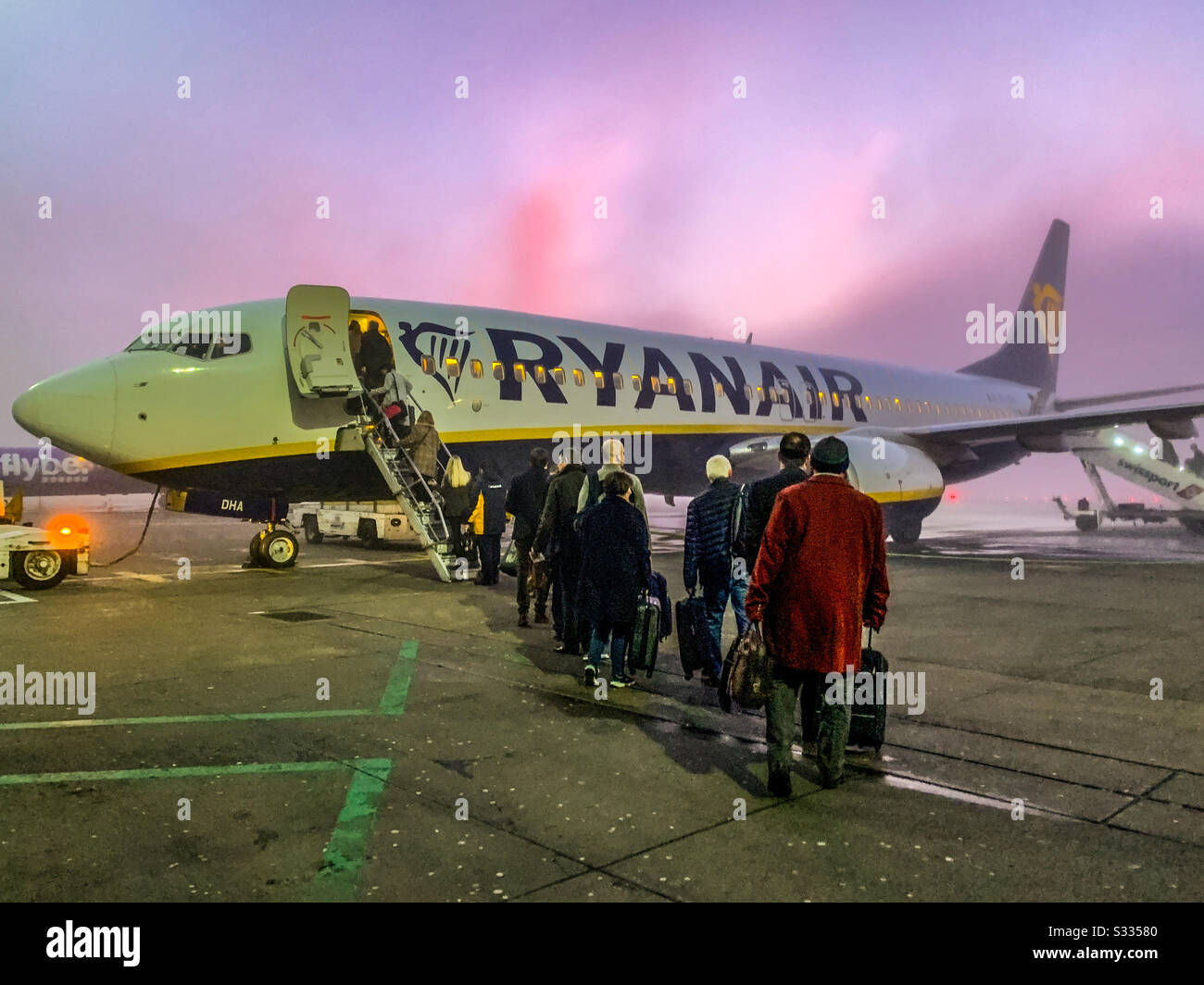 Schlange, um einen frühen Morgenflug auf einer Boeing 737-8AS Ryanair am Flughafen Manchester zu starten Stockfoto