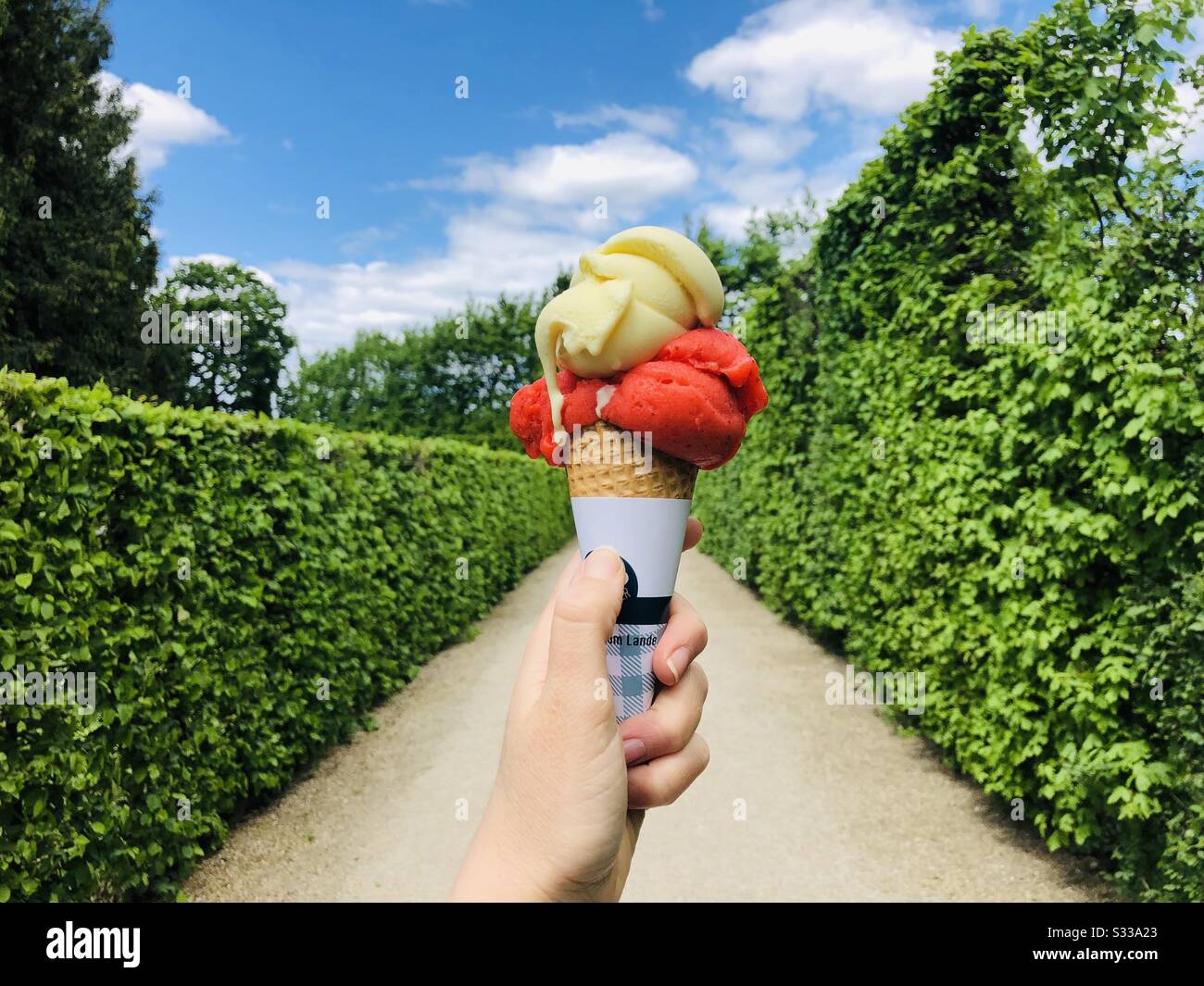 Hand mit farbenfrohem Eiskegel Stockfoto
