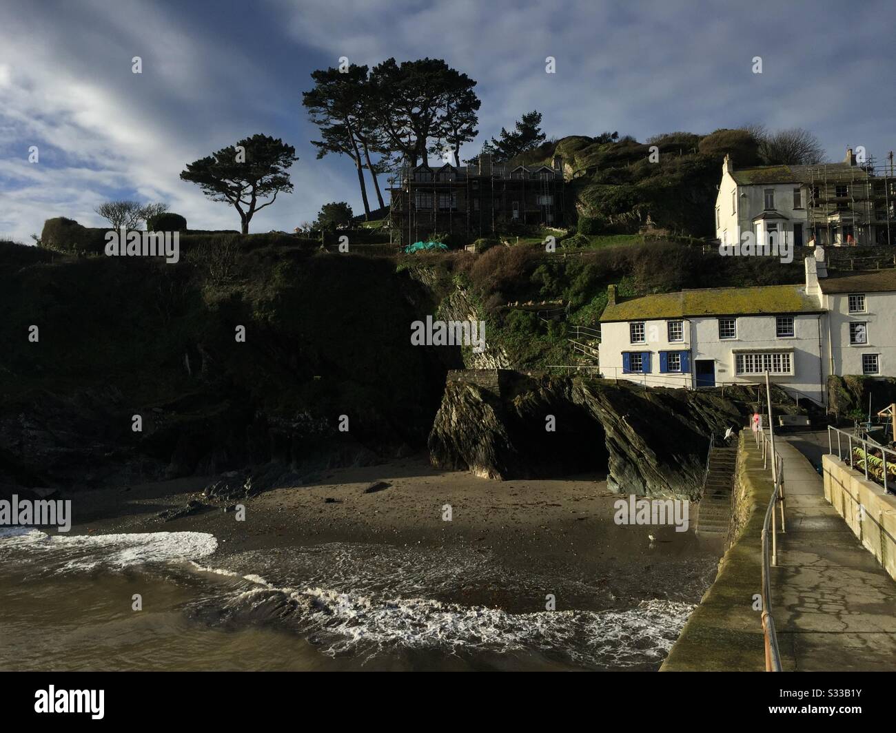 Cottages werden neben der Hafenmauer bei Polperro in Cornwall gebaut. Stockfoto