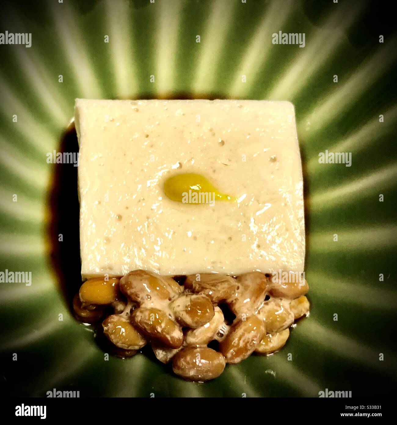Natto (japanische fermentierte Sojabohnen) und Tofu auf einer grünen Keramikschale - Smartphone-aufgenommenes Stockfoto
