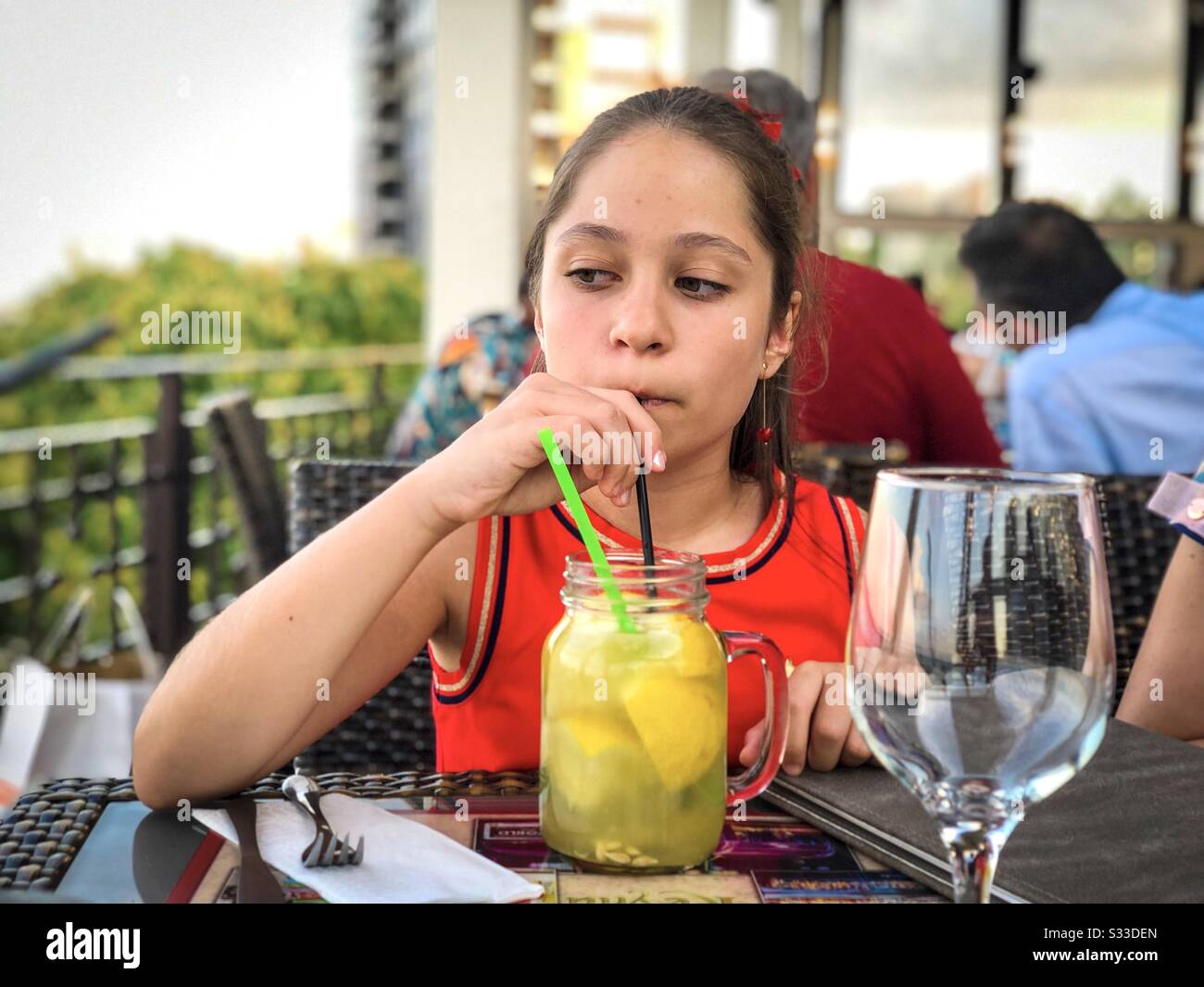 Mädchen trinkt Limonade in einem Restaurant Stockfoto