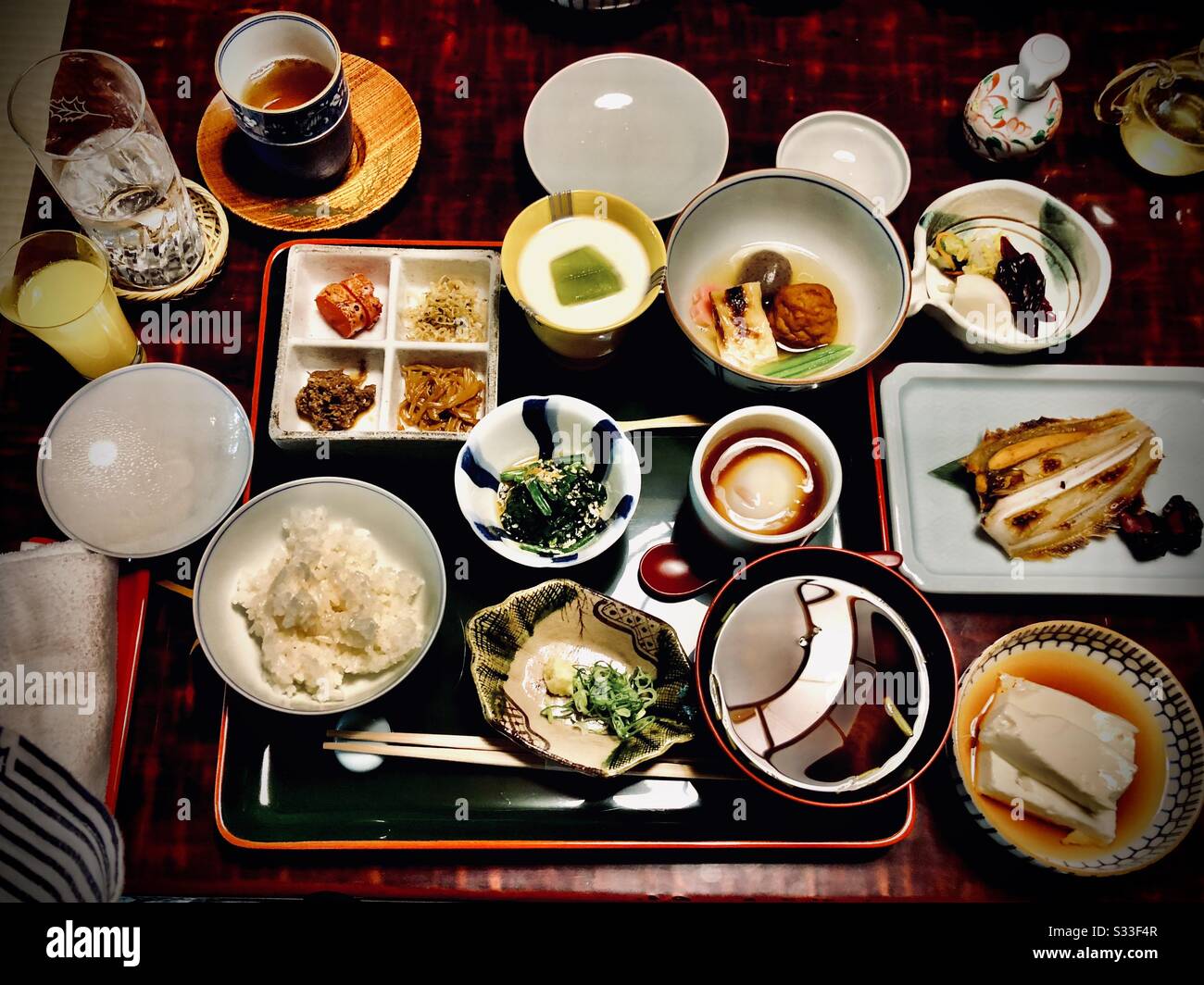 Traditionelles japanisches Frühstück in einem Ryokan: Tofu, Reis, rote Miso-Suppe, gegrillter Fisch, Gemüse und Pickles Stockfoto