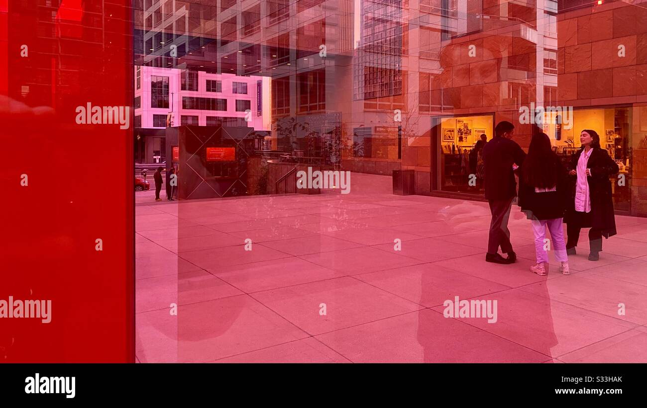Los ANGELES, CA, JAN 2020: Die Gruppe steht in der Nähe des Museum of Contemporary Art in Downtown, das durch transparente und reflektierende, pinkfarbene und rote Plexiglaskunstinstallationen gesehen wird Stockfoto