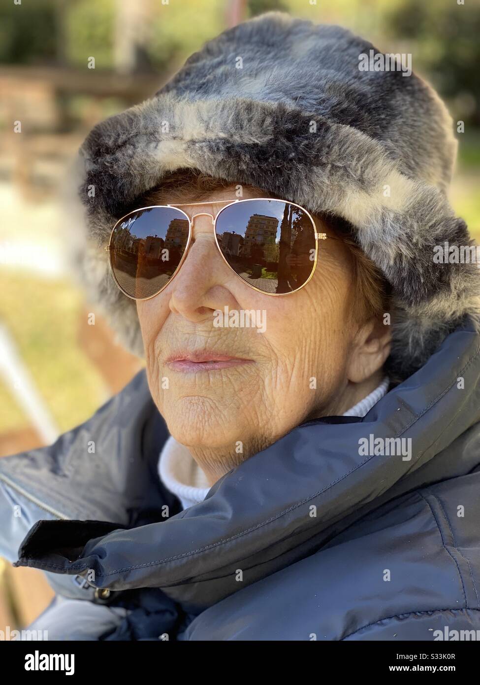 Porträt einer neunzigjährigen Frau mit Sonnenbrille während eines Wintertags Stockfoto