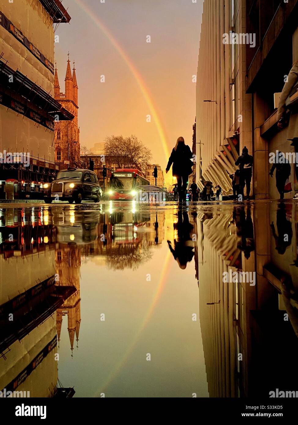 Wetter in Großbritannien: Ein Regenbogen scheint über das Walkie-Talkie-Gebäude, wie es sich auf einer verregneten Straße im Holborn Viaduct, London, England widerspiegelt. Stockfoto