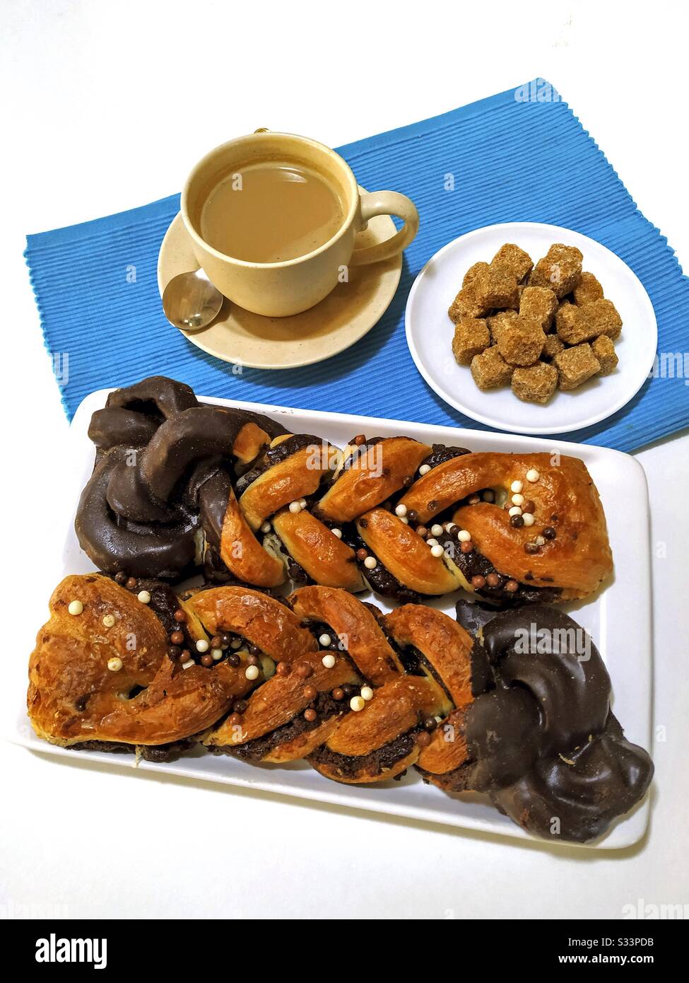 Frühstück. Weißer Kaffee und Gebäck. Stockfoto