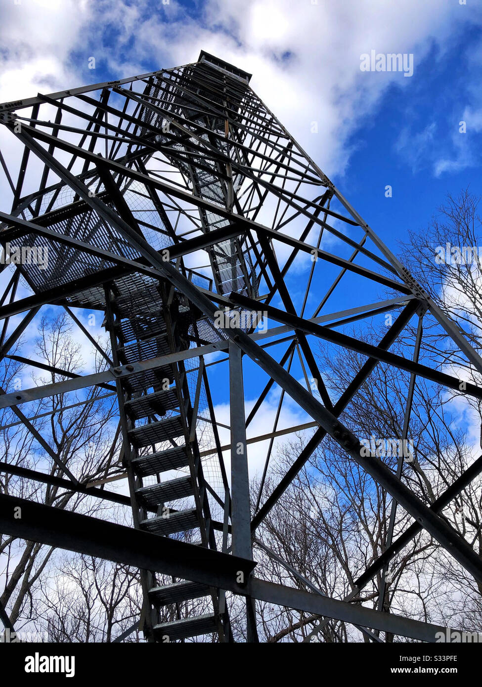 Feuerwehrturm Wachturm mit Mann steigt auf, um nach Gefahr zu suchen - Smartphone-aufgenommenes Stockfoto