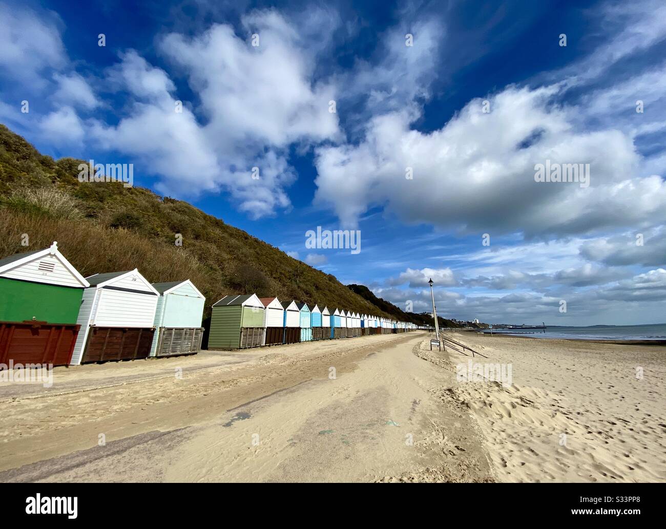 Eine Reihe von Strandhütten an der Promenade von Bournemouth im Winter mit einem tollen Himmel, Großbritannien. Stockfoto