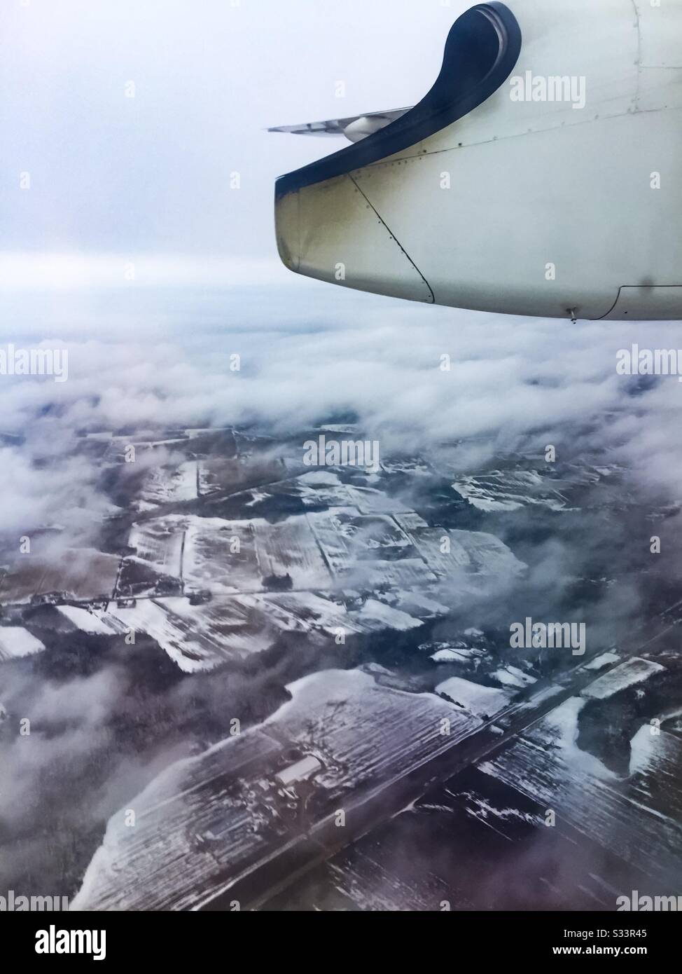 Kleines Flugzeug über schneebedeckter Winterlandschaft, Ontario, Kanada. Exurbia. - Smartphone-aufgenommenes Stockfoto