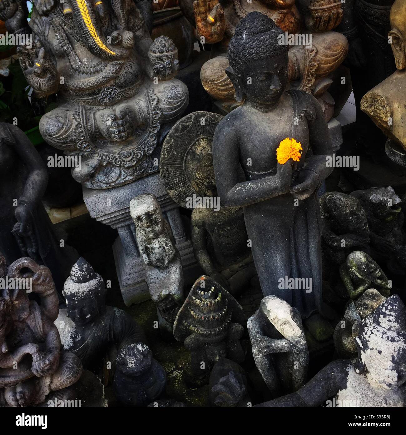 Buddha, Ganesha und andere Statuen, die im Souvenirladen, Candidasa, Bali, Indonesien, zum Verkauf stehen - Smartphone-aufgenommenes Stockfoto
