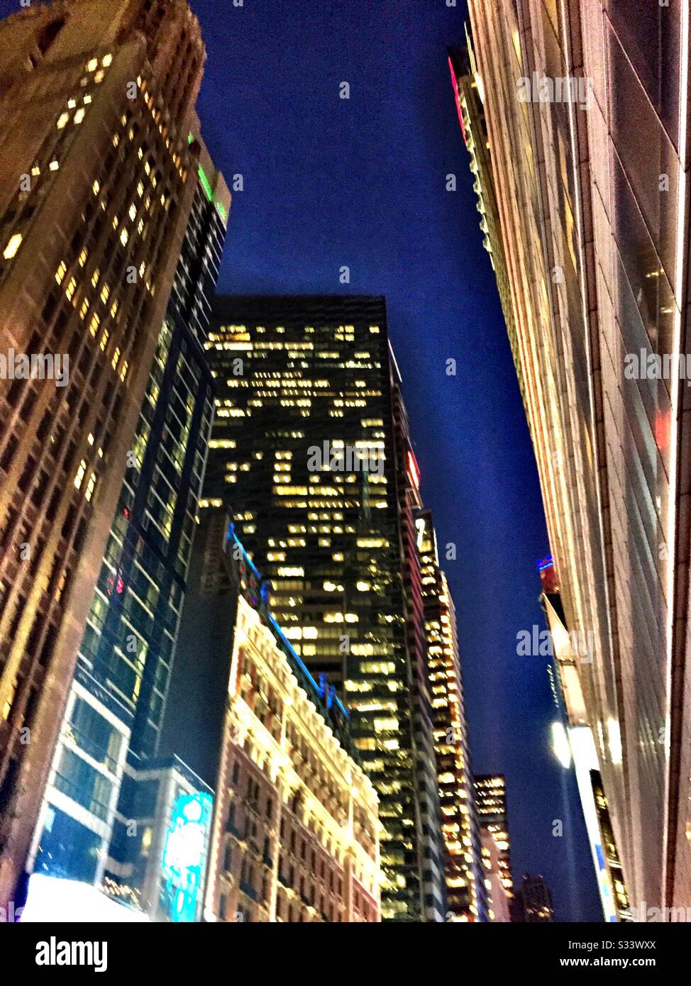 Bunte helle Lichter und Bürogebäude auf der 42. St. in der Nähe Des Times Square in Midtown Manhattan, New York City, USA - Smartphone-aufgenommenes Stockfoto