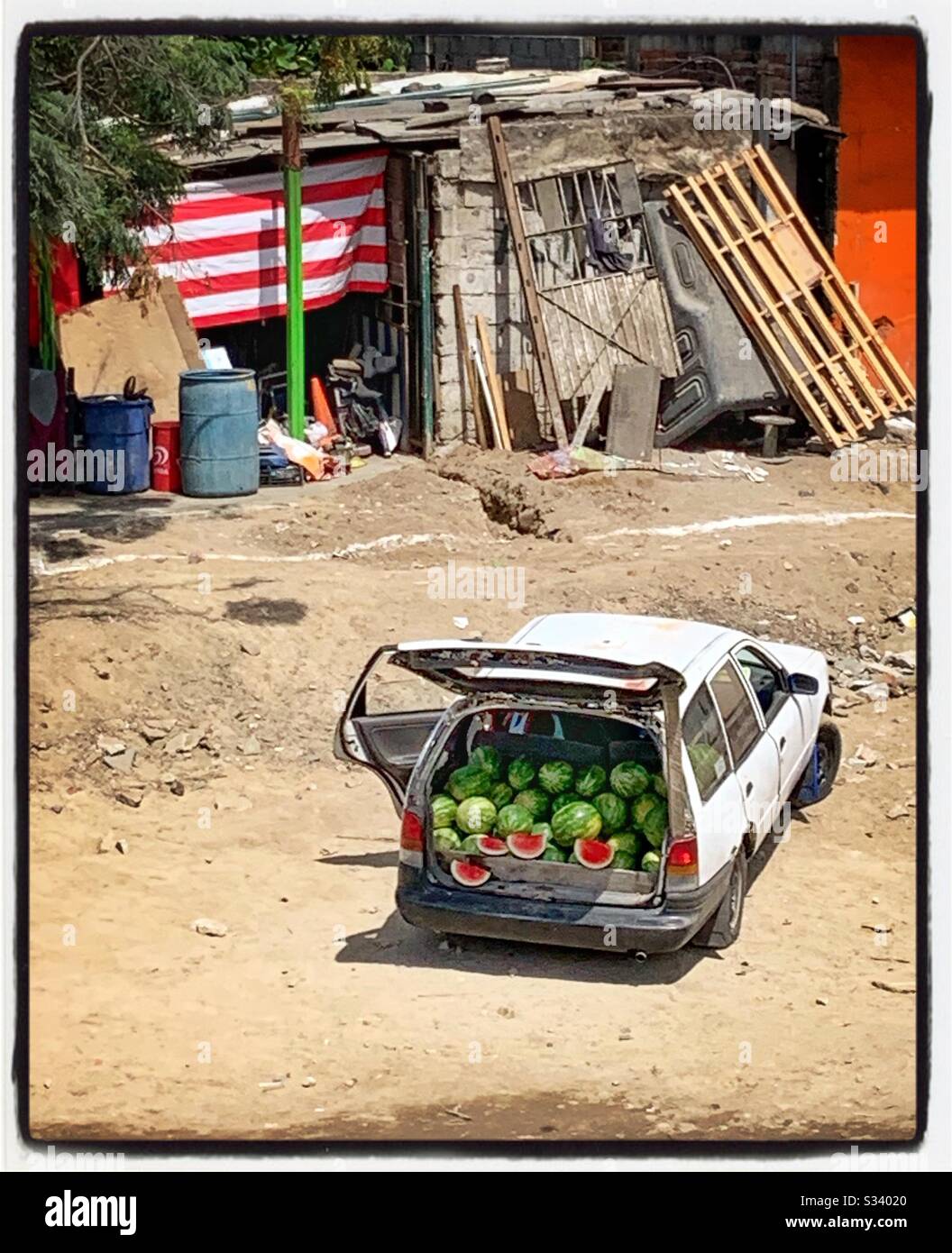 Die Rückseite eines Fahrzeugs ist mit süßen, saftigen Wassermelonen gefüllt, die in einem farbenfrohen Display in einem ländlichen Gebiet von Mexiko zum Verkauf angeboten werden. Stockfoto