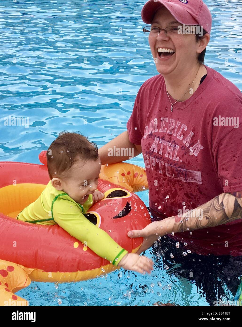 Mutter mit Baby, Kleinkind im Schwimmbad. Lachen. Klares Wasser. Frohe Zeiten. Stockfoto