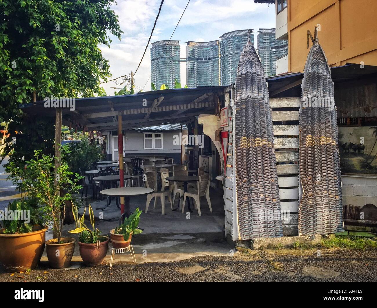 Gedruckte Ausschnitte der Petronas Twin Towers schmücken ein Restaurant in der Hinterstraße, Kampung Baru, Kuala Lumpur, Malaysia Stockfoto