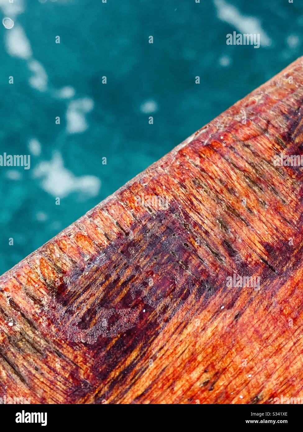 Ein Detail einer verwitterten Holzboot-Deck-Schiene. - Smartphone-aufgenommenes Stockfoto
