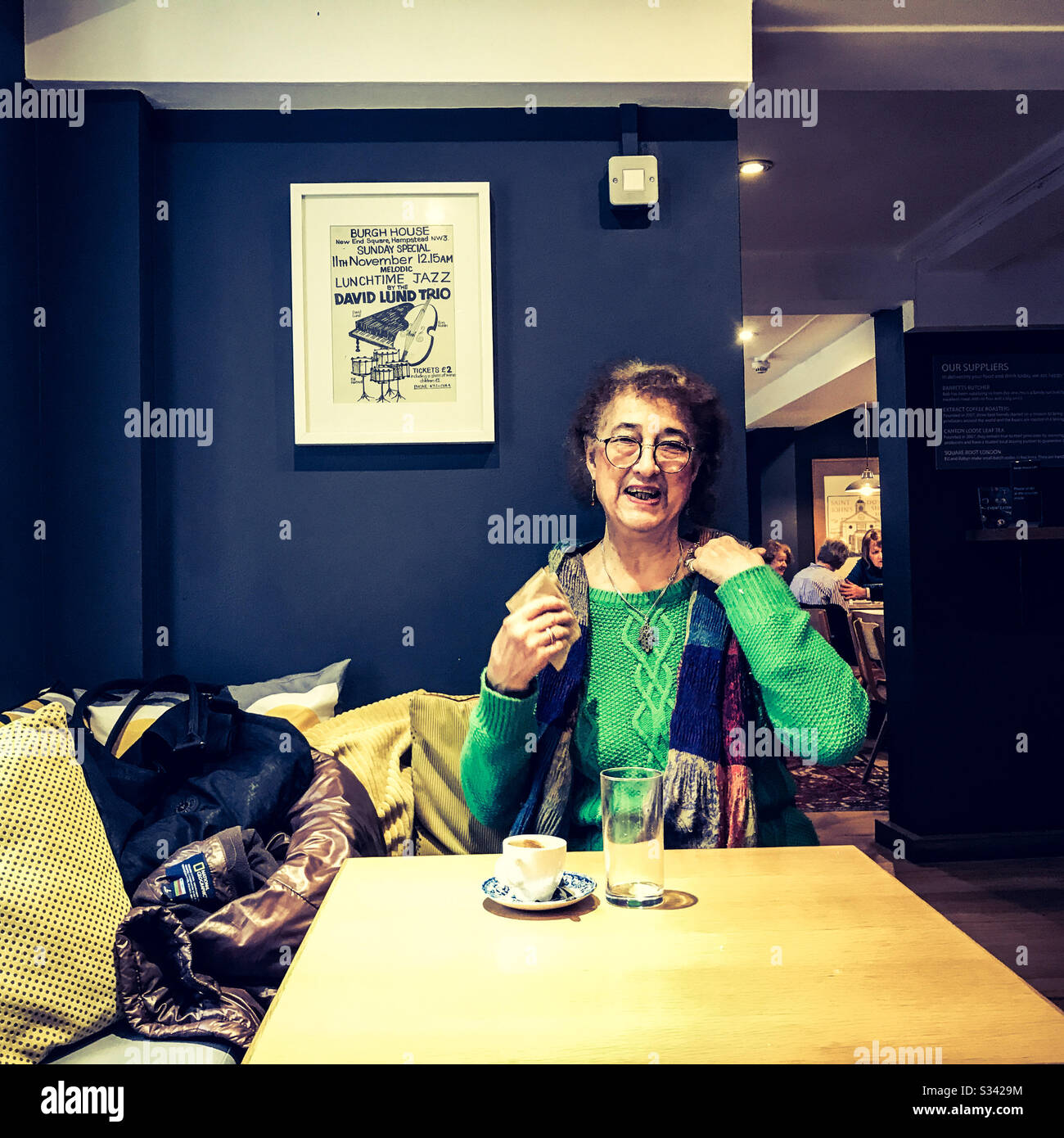 Eine Frau, die in guter Laune lächelt und einen Kaffee und ein Getränk in einem Café-Tischporträt genießt Stockfoto