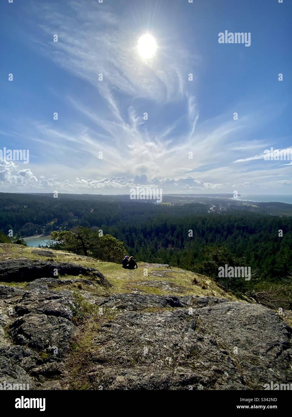 Zwei Wanderer genießen den malerischen Blick nach Süden über die Insel Whidbey Island, Washington State, USA - Smartphone-aufgenommenes Stockfoto