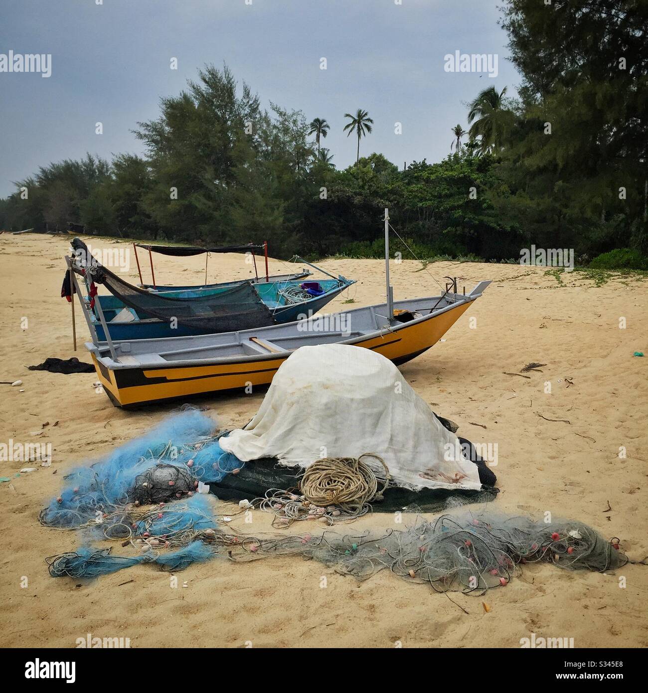 Fischernetze und kleine traditionelle Boote am Strand, Batu Rakit, Terengganu, Malaysia - Smartphone-aufgenommenes Stockfoto