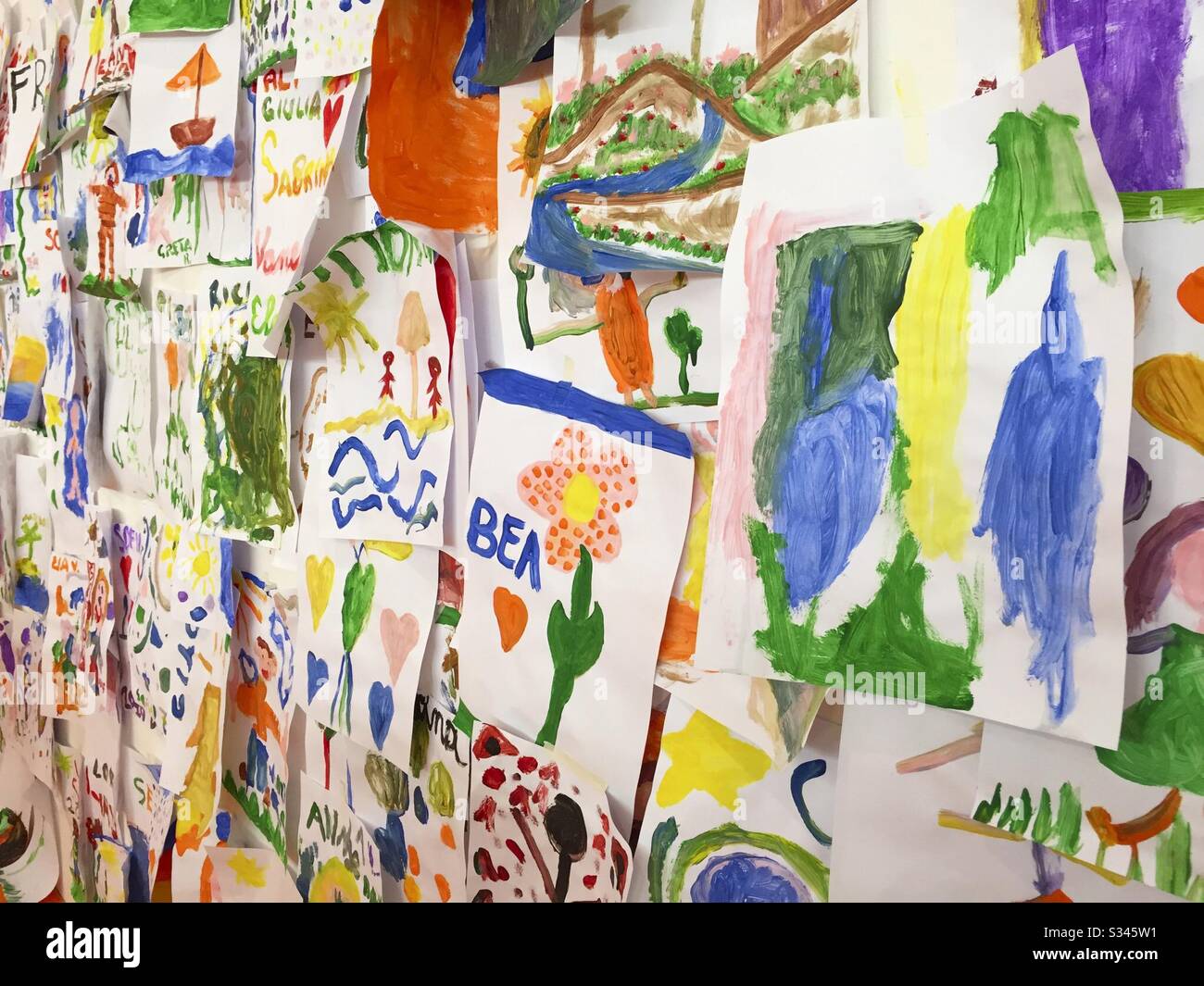 Bunte Kinderbilder an der Wand - Smartphone-aufgenommenes Stockfoto