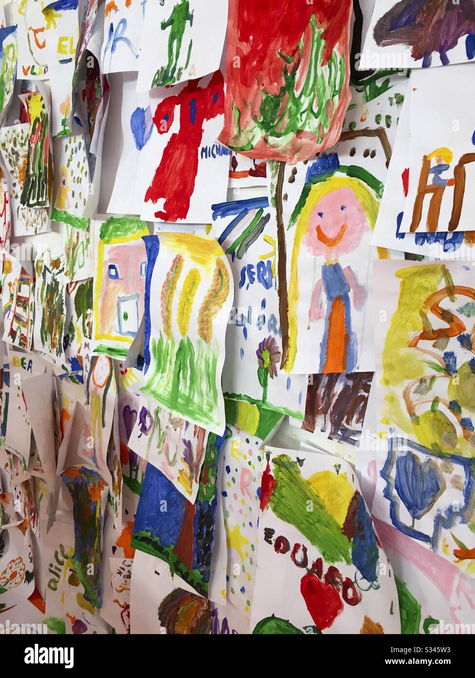 Bunte Kinderbilder an der Wand - Smartphone-aufgenommenes Stockfoto