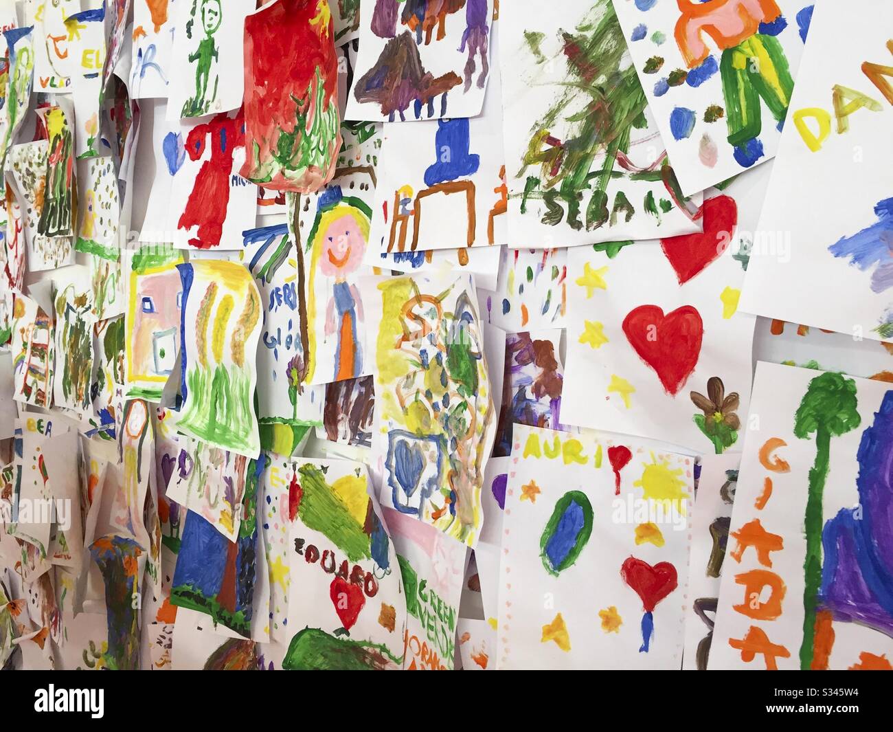 Bunte Kinderbilder an der Wand - Smartphone-aufgenommenes Stockfoto