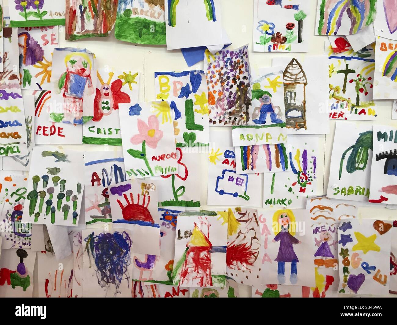 Bunte Kinderbilder an der Wand - Smartphone-aufgenommenes Stockfoto