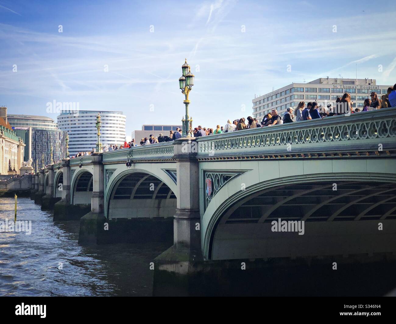 Ein weiter Blick auf Touristen, die auf der Westminster Bridge über die Themse in London stehen Stockfoto