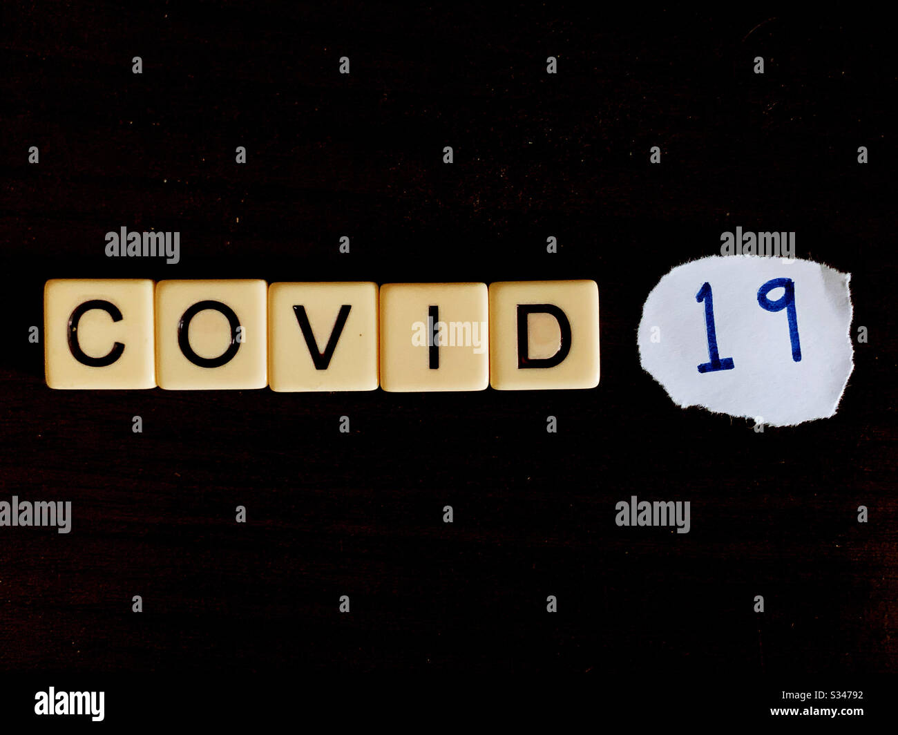 Covid 19 mit Buchstabenkacheln - Smartphone-aufgenommenes Stockfoto