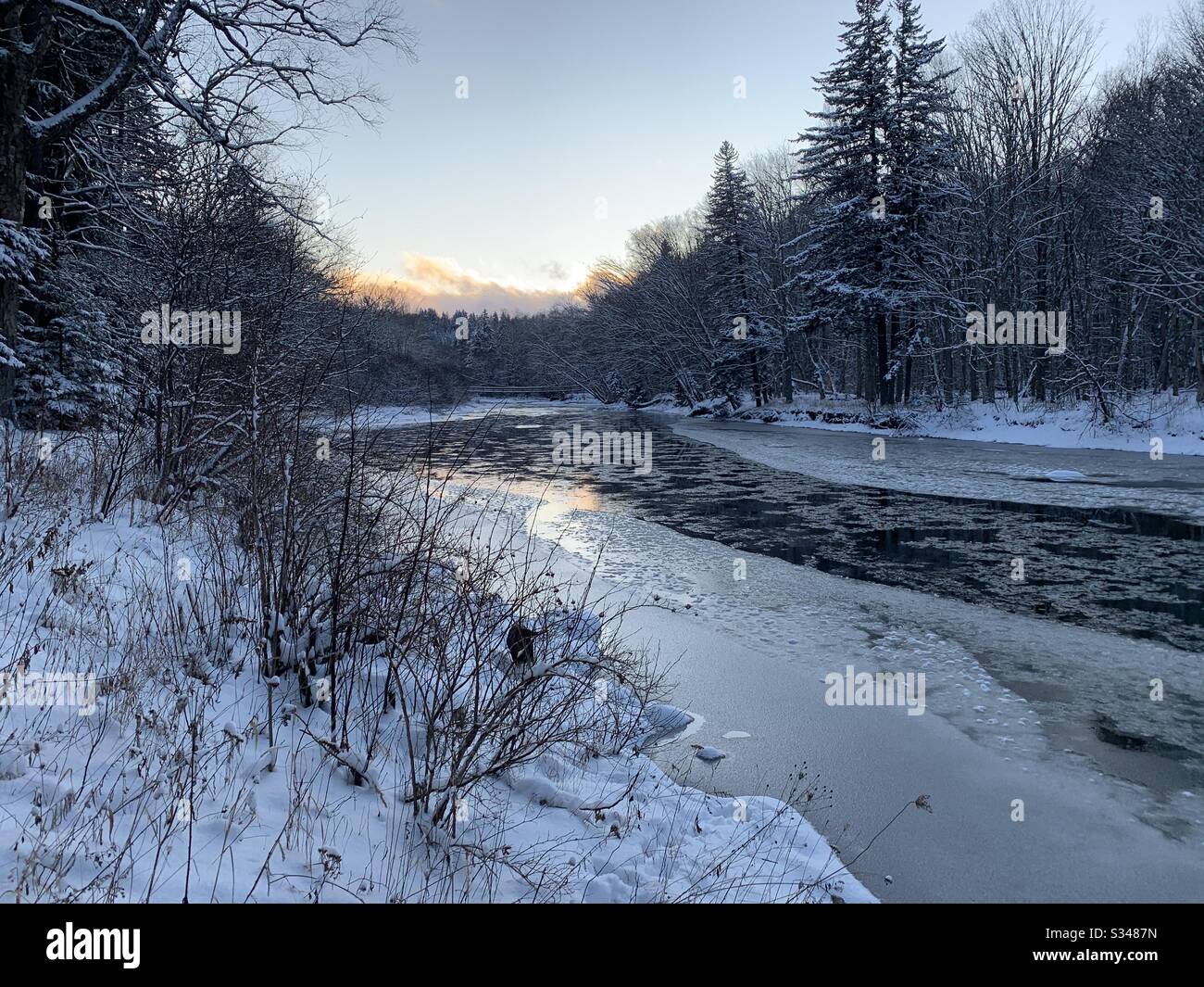 Sonnenuntergang über einem eisbemehlten Fluss. Stockfoto