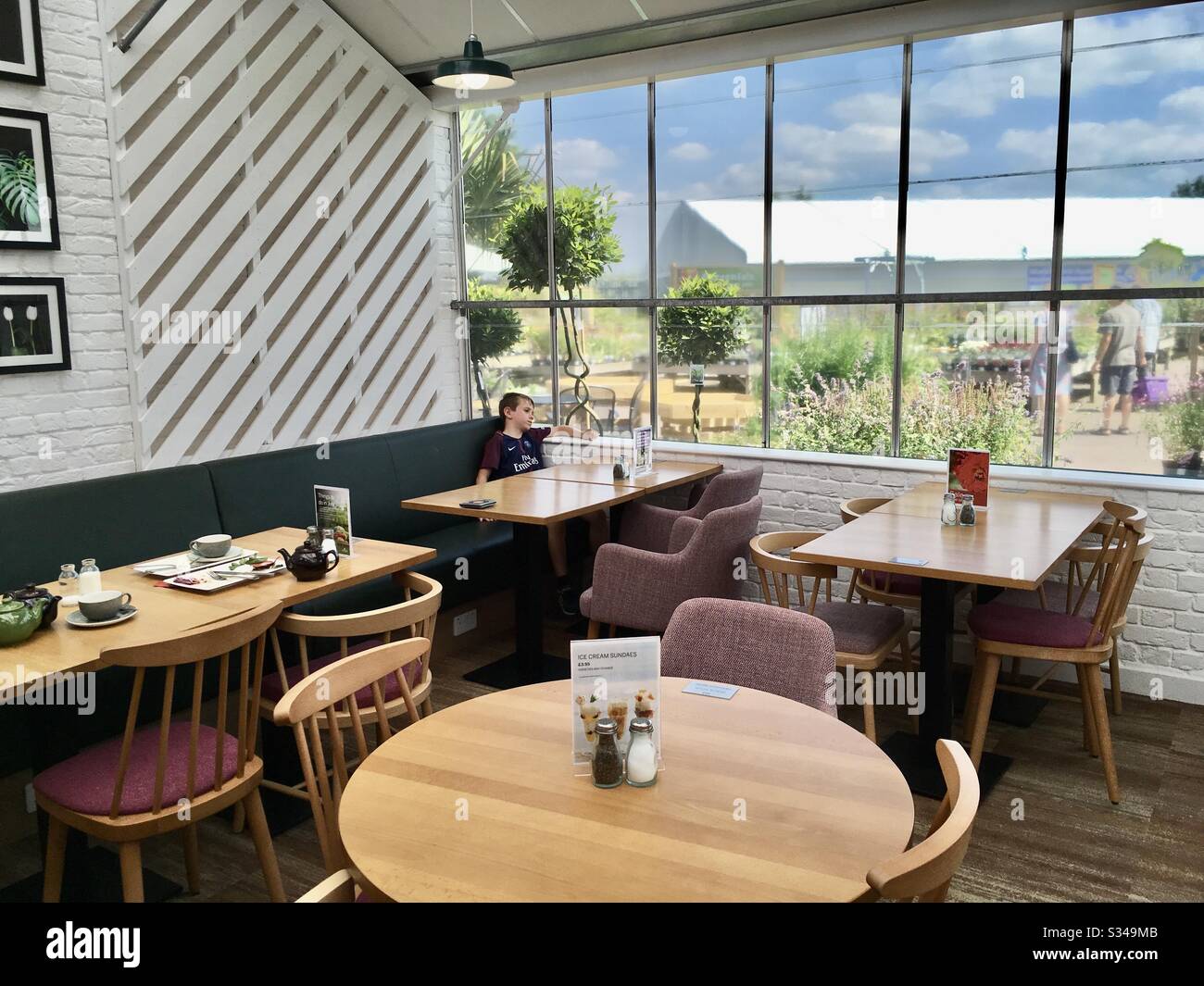 Junge im Café im Gartencenter Stockfoto