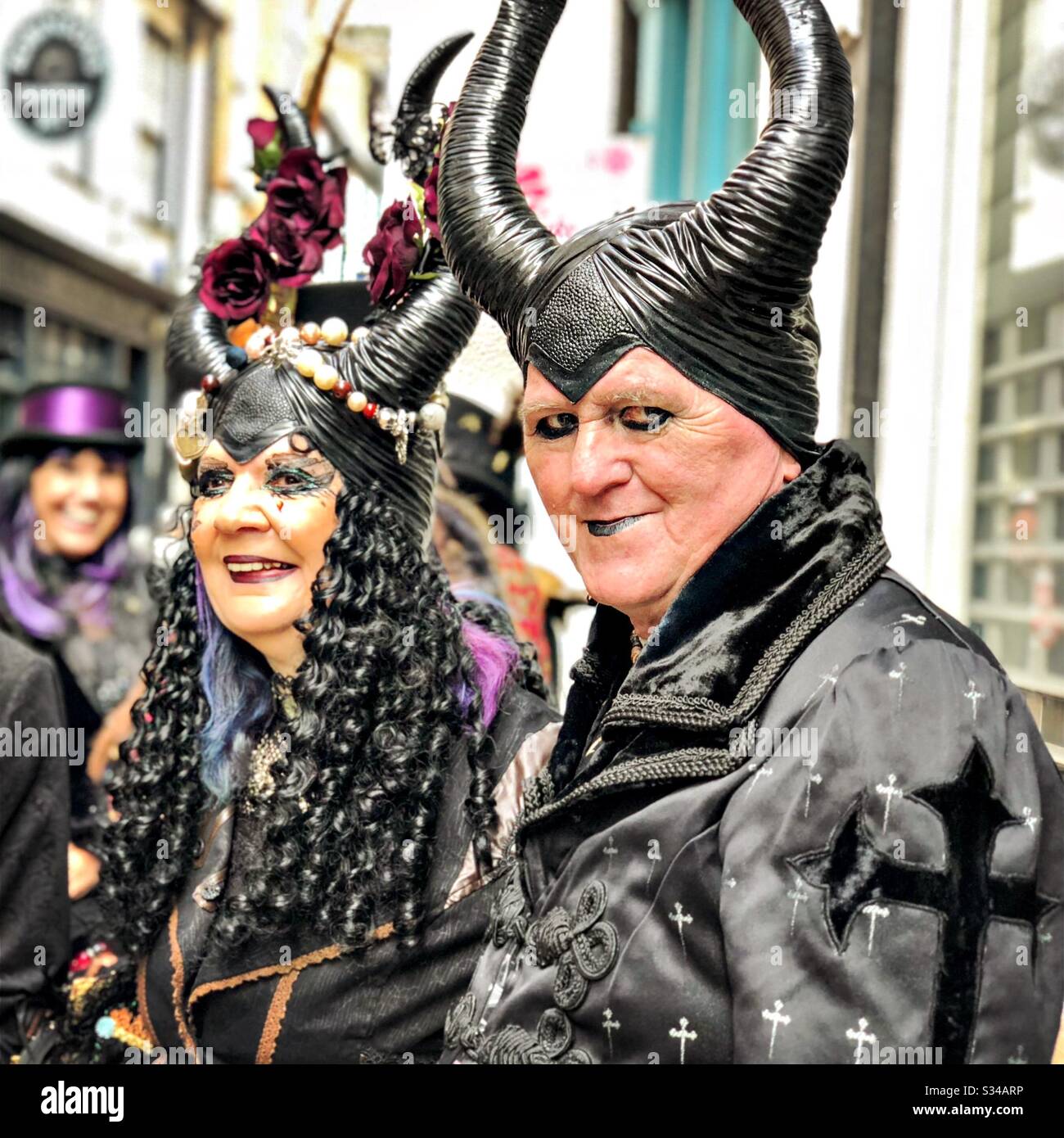 Menschen in kreativen Kostümen während einer Cosplay-Veranstaltung. Whitby Goth Weekend. Ältere Männer und Frauen tragen Hörner und schwarze Satan-Outfits - Smartphone-aufgenommenes Stockfoto