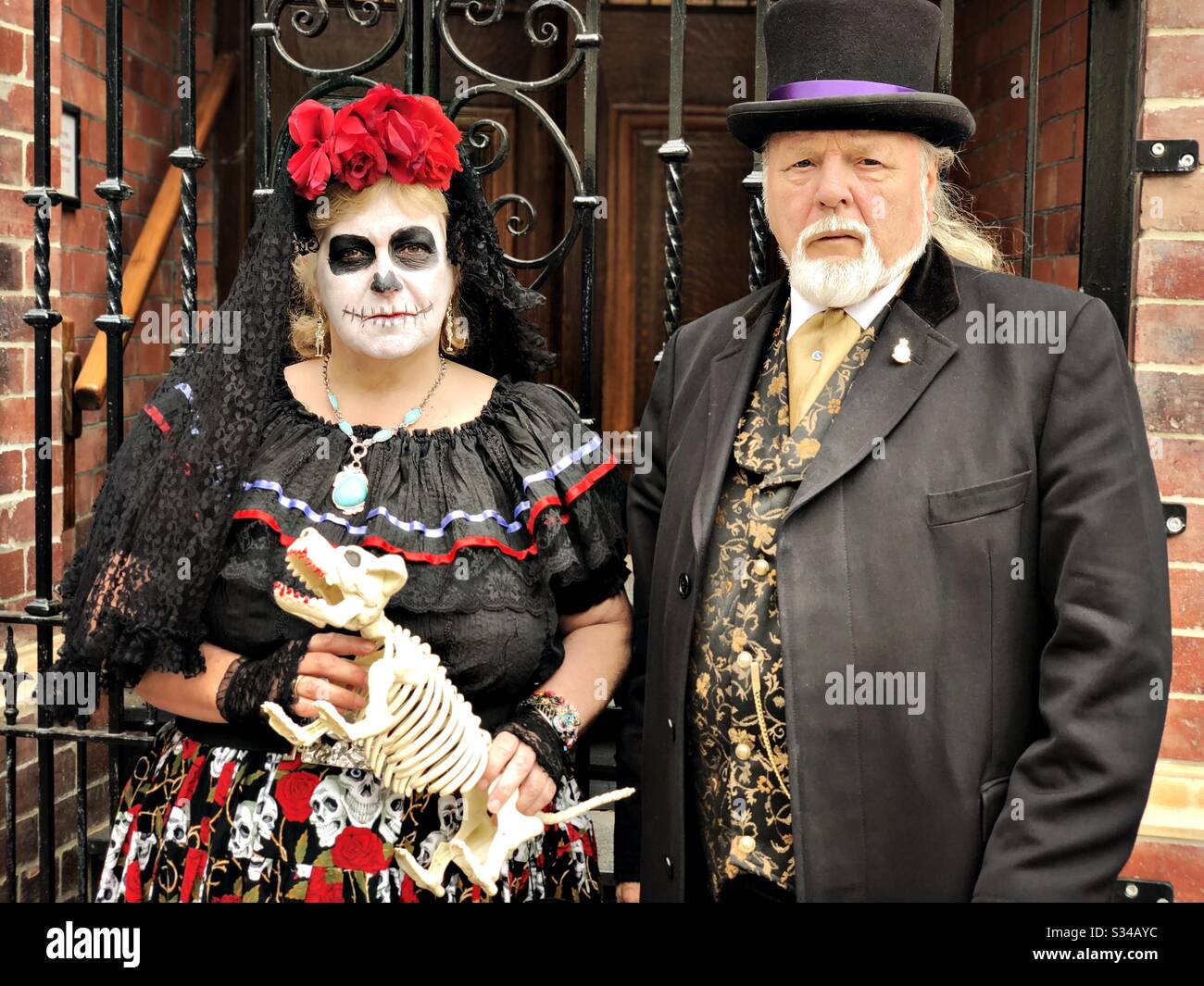 Person in einem kreativen Kostüm während einer Cosplay-Veranstaltung. Whitby Goth Weekend. Älterer Mann und Frau mit Skeletthund Stockfoto