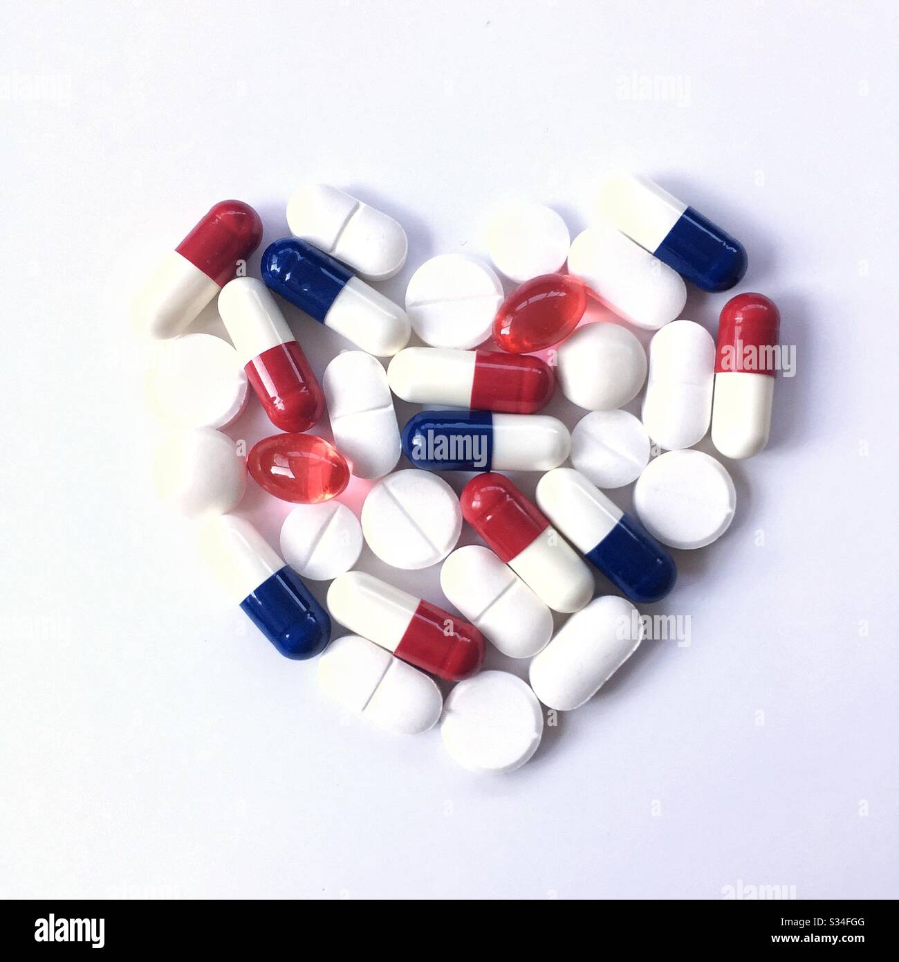 Eine Herzform aus verschreibungspflichtigen Medikamenten wie Paracetamol, Pillen und Tabletten auf weißem Hintergrund Stockfoto