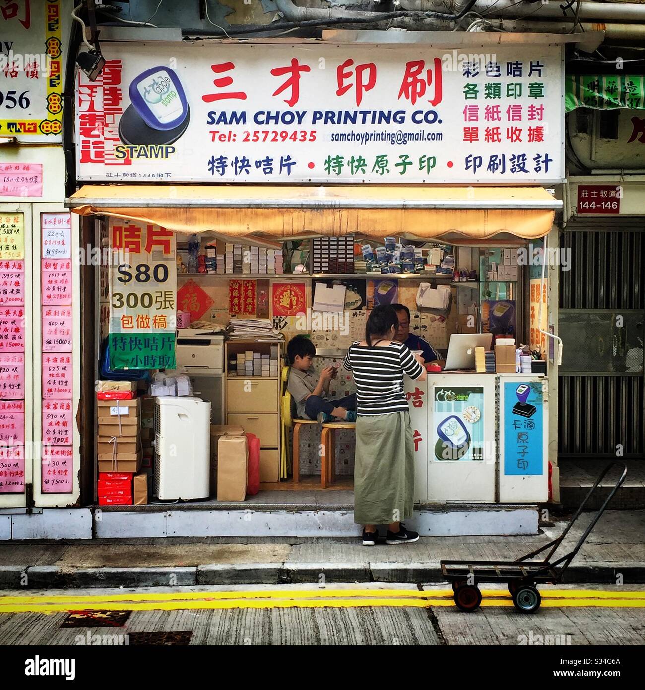 Ein Händler für Visitenkarten und Gummistempel arbeitet von einem winzigen Ort in WAN Chai, Hong Kong Island - Smartphone-aufgenommenes Stockfoto