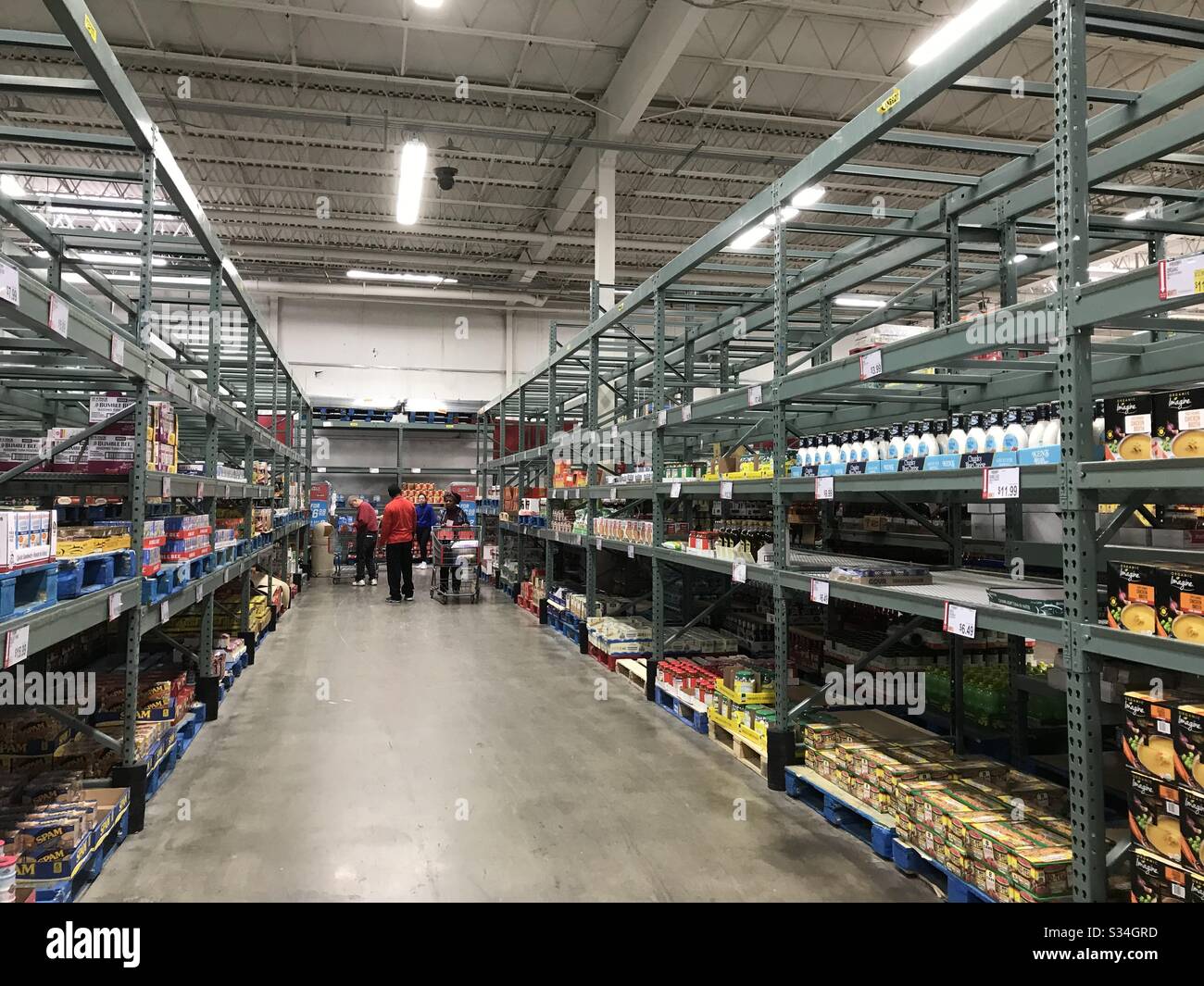 Menschen, die während der Coronavirus-Krise in New Jersey USA in halb leeren Lebensmittelregalen im Clubsupermarkt einkaufen Stockfoto