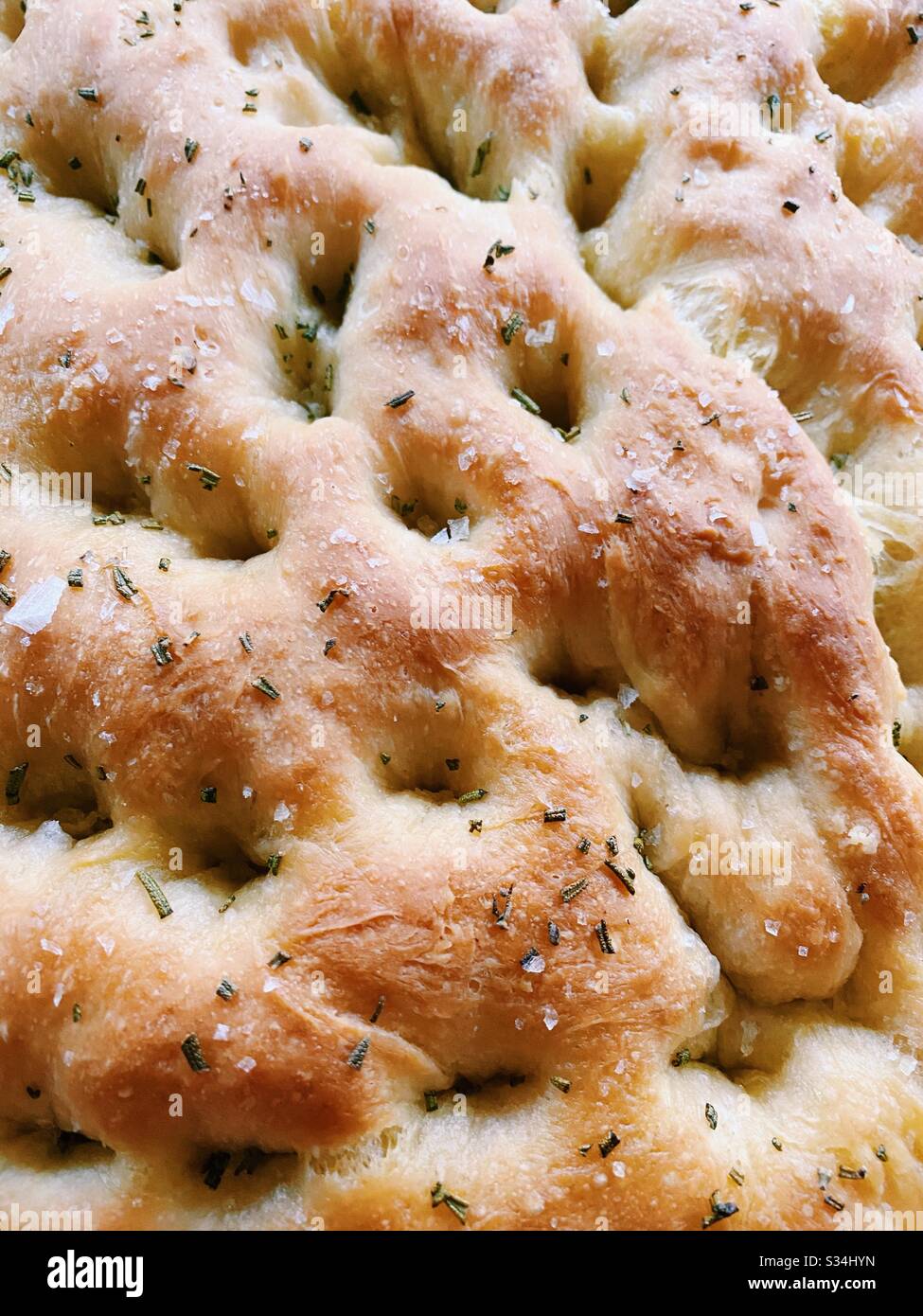 Nahaufnahme von hausgemachtem Focaccia-Brot mit Rosmarin und Meersalz. - Smartphone-aufgenommenes Stockfoto