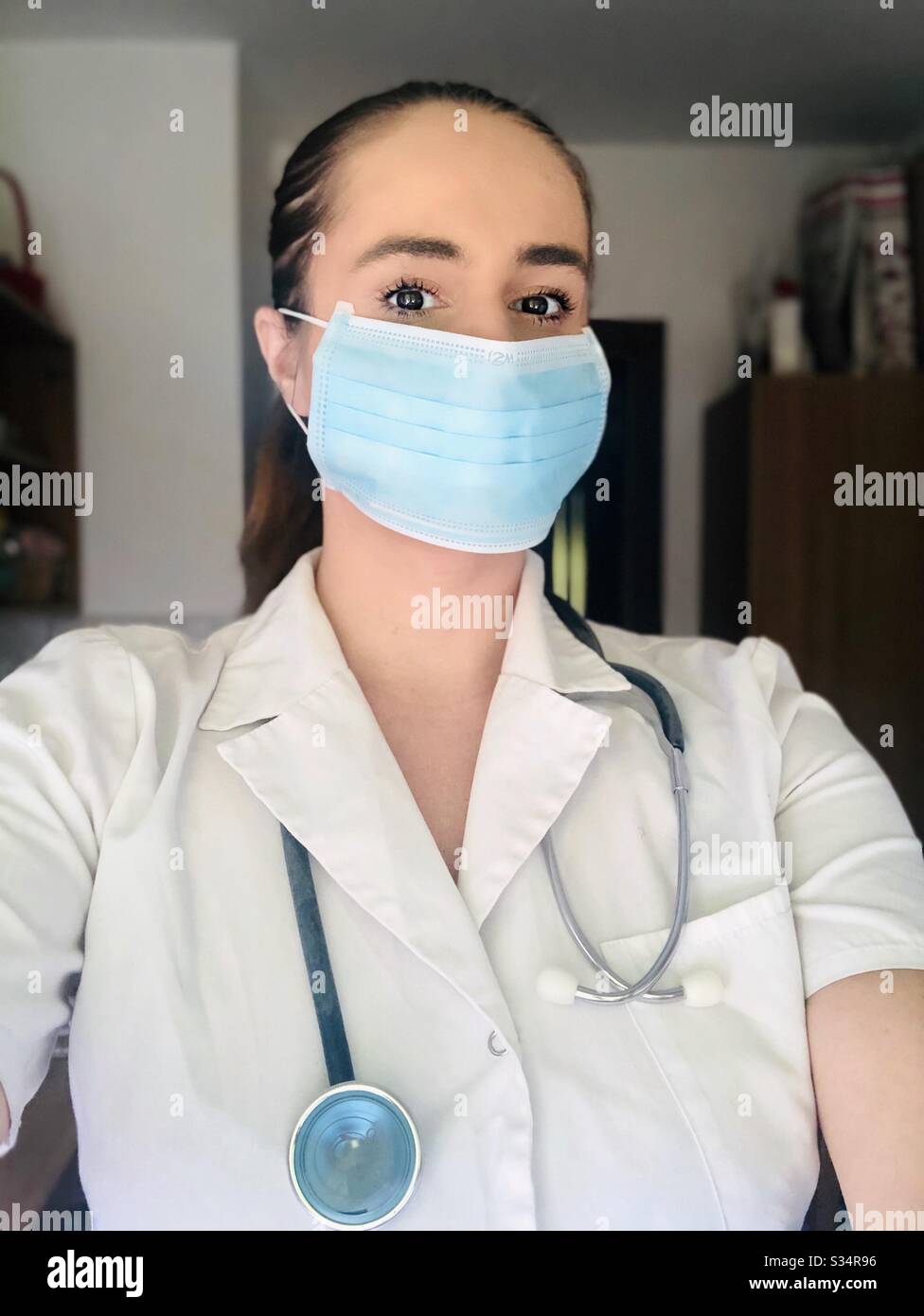 Medizinische Praktikantin trägt Maske und Stethoskop Stockfoto