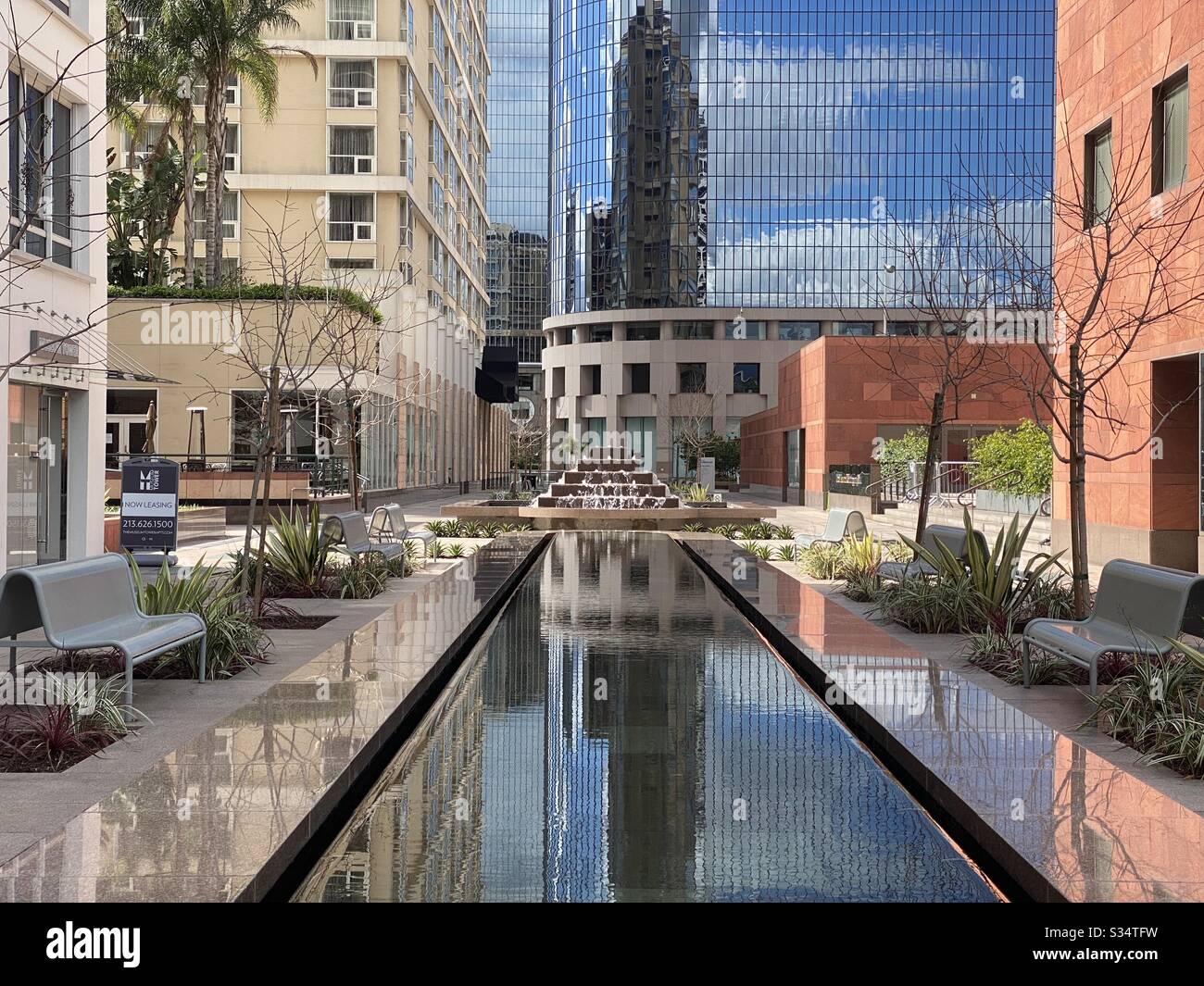 LOS ANGELES, CA, MAR 2020: Bunte Wohnung- und Bürogebäude, die sich im Pool im Pocket Park neben dem California Plaza in der Innenstadt widerspiegeln - Smartphone-aufgenommenes Stockfoto