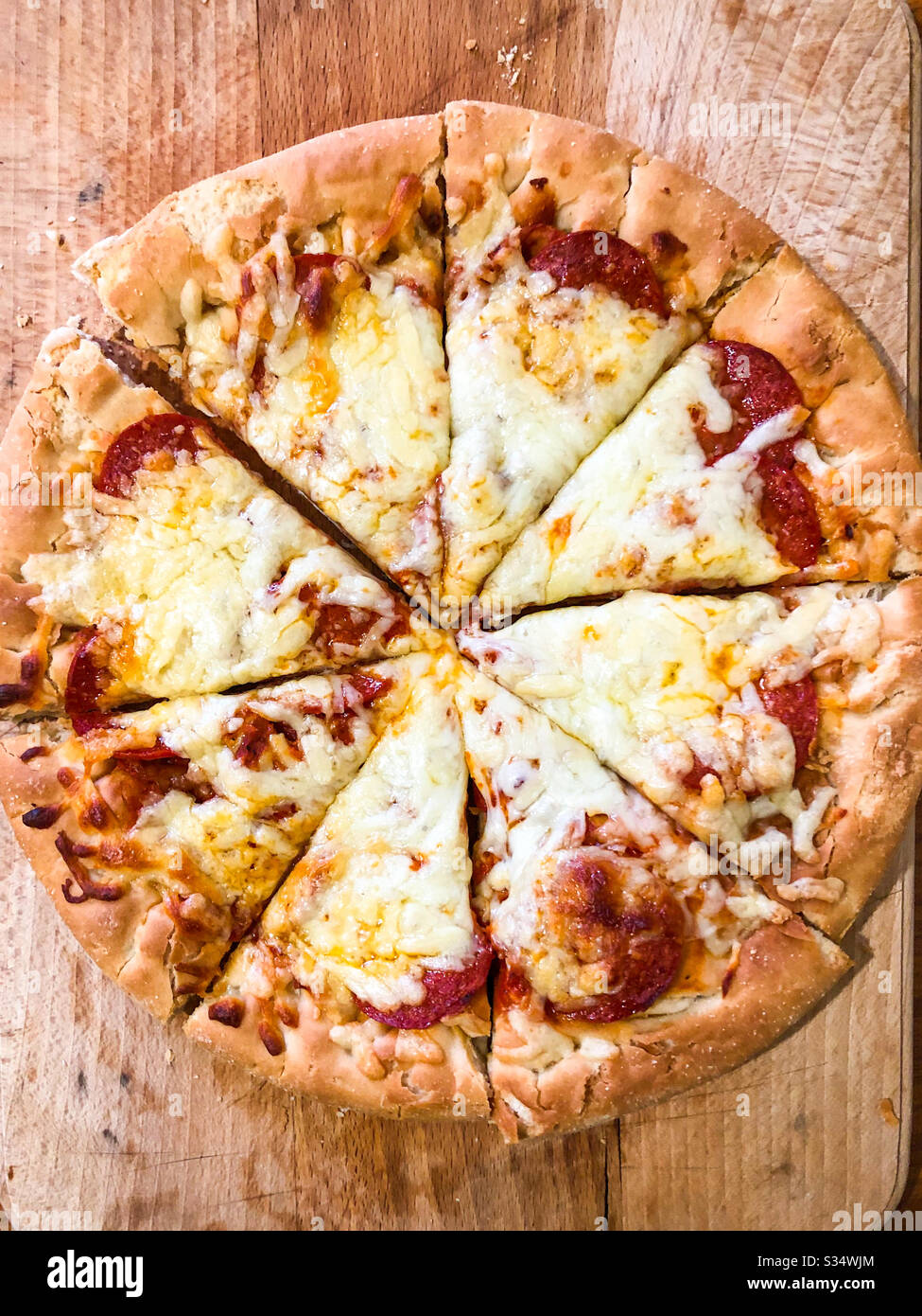 Tiefes Pfannenkäse und Pfefferoni Pizza auf einem Holzhackbrett. Stockfoto