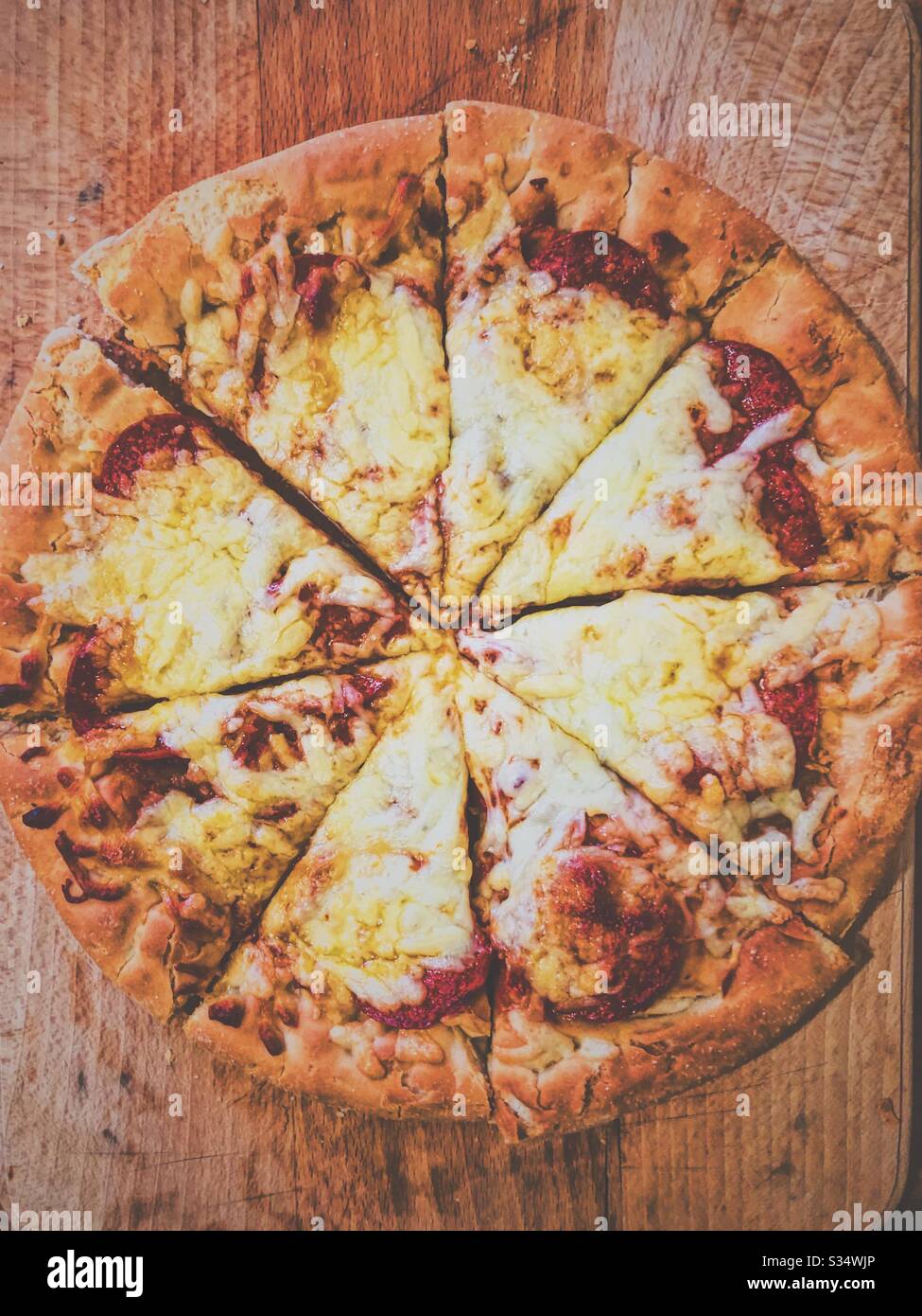 Tiefes Pfannenkäse und Pfefferoni Pizza auf einem Holzhackbrett. Stockfoto
