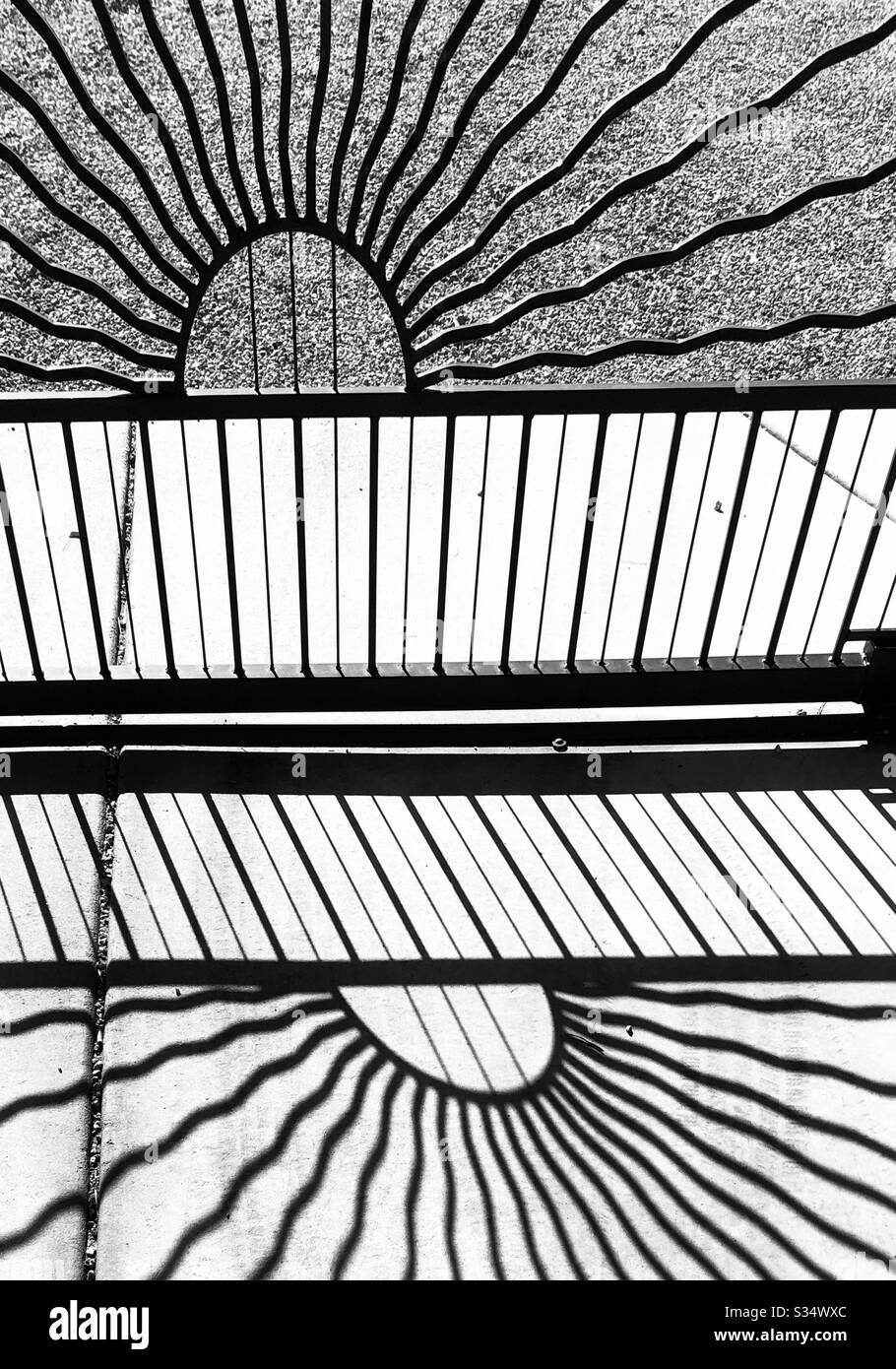 Schwarz weiß, Schatten, Eisentor, Zementeinfahrt, gerade Linien, Teilkreis, Sonnenplatzwand, abstrakt Stockfoto