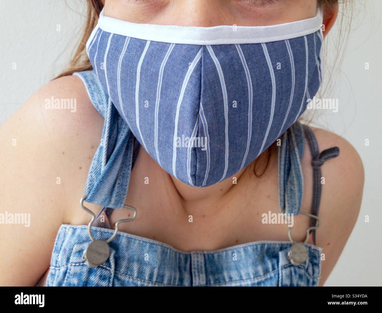 Nahaufnahme des Teenager-Mädchens, das eine Gesichtsmaske trägt, um sich vor Viren zu schützen Stockfoto