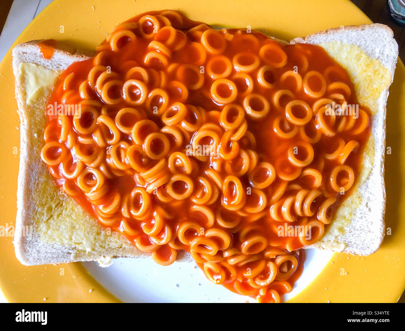 Spaghetti klingelt in Tomatensauce auf gebuttertem Toast. Stockfoto