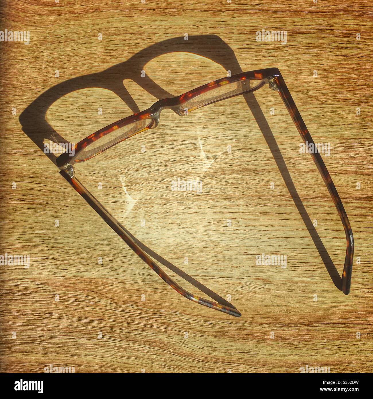 Brille mit Schatten auf dem Tisch Stockfoto