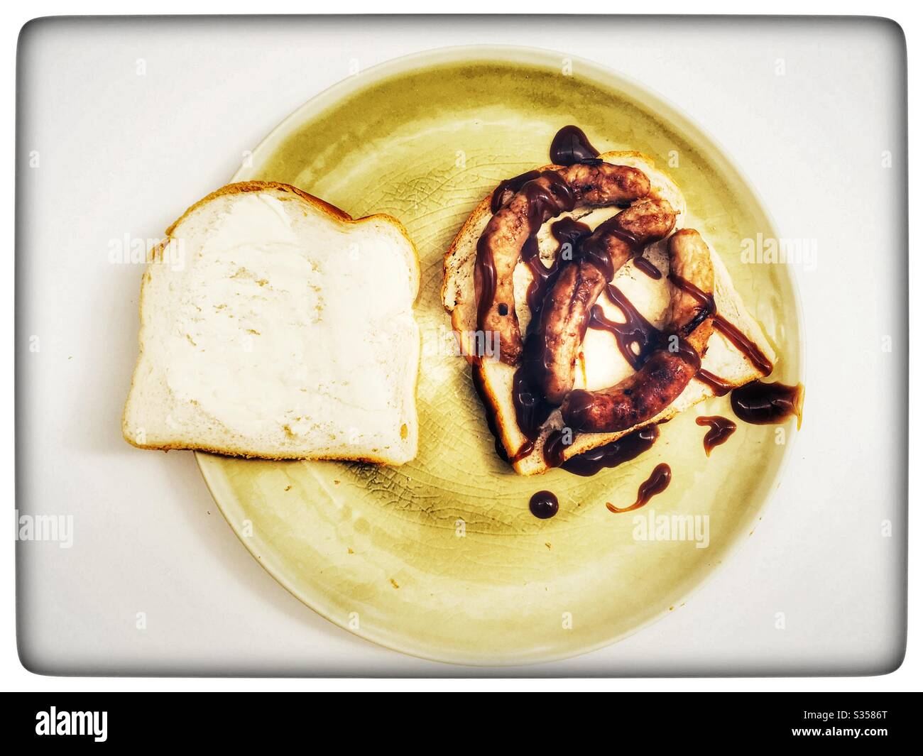 Wurst-Sandwich mit brauner Sauce - Smartphone-aufgenommenes Stockfoto