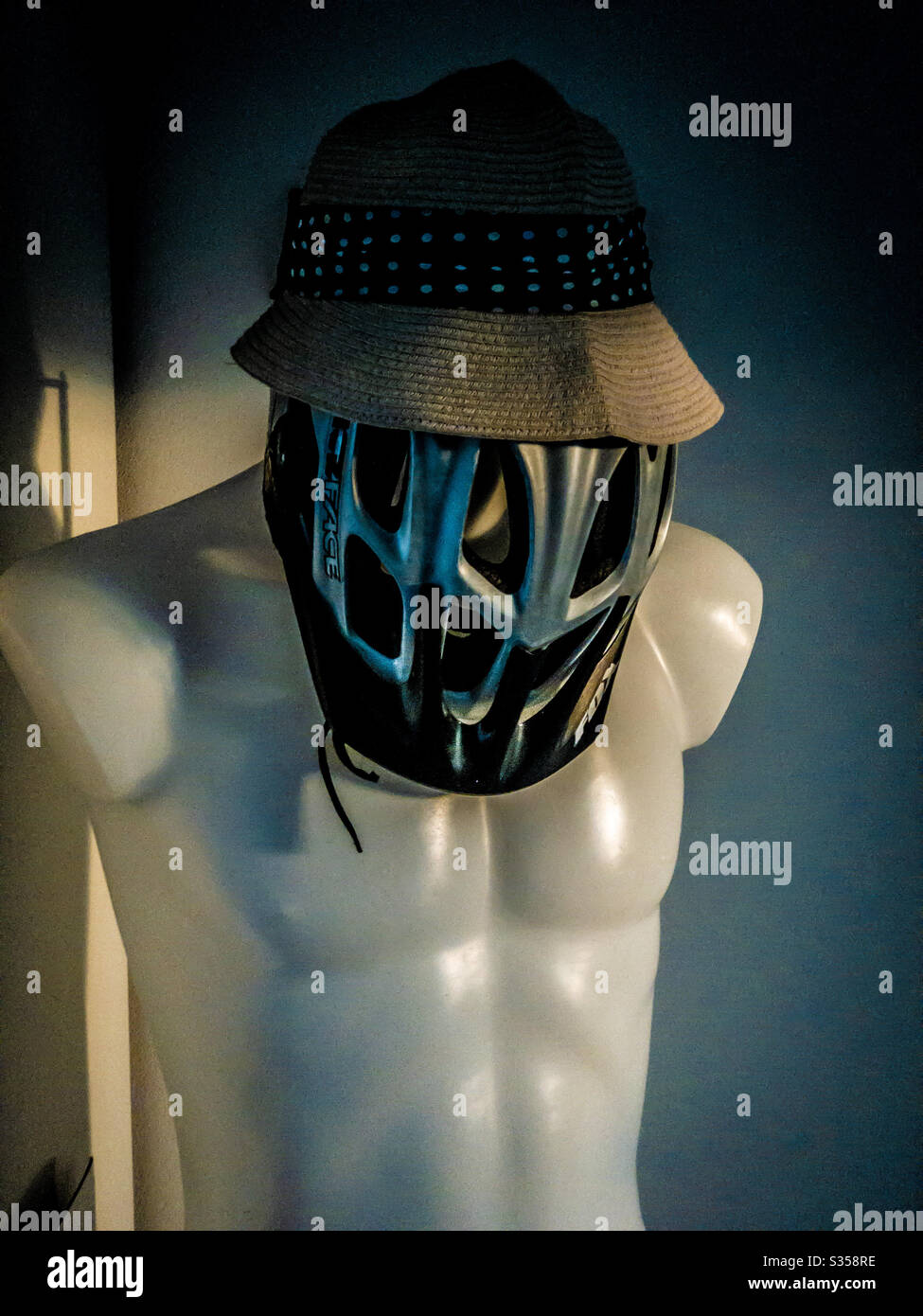 Weiße Schaufensterpuppe mit Radsport Hut als Maske und Strohhut - Smartphone-aufgenommenes Stockfoto